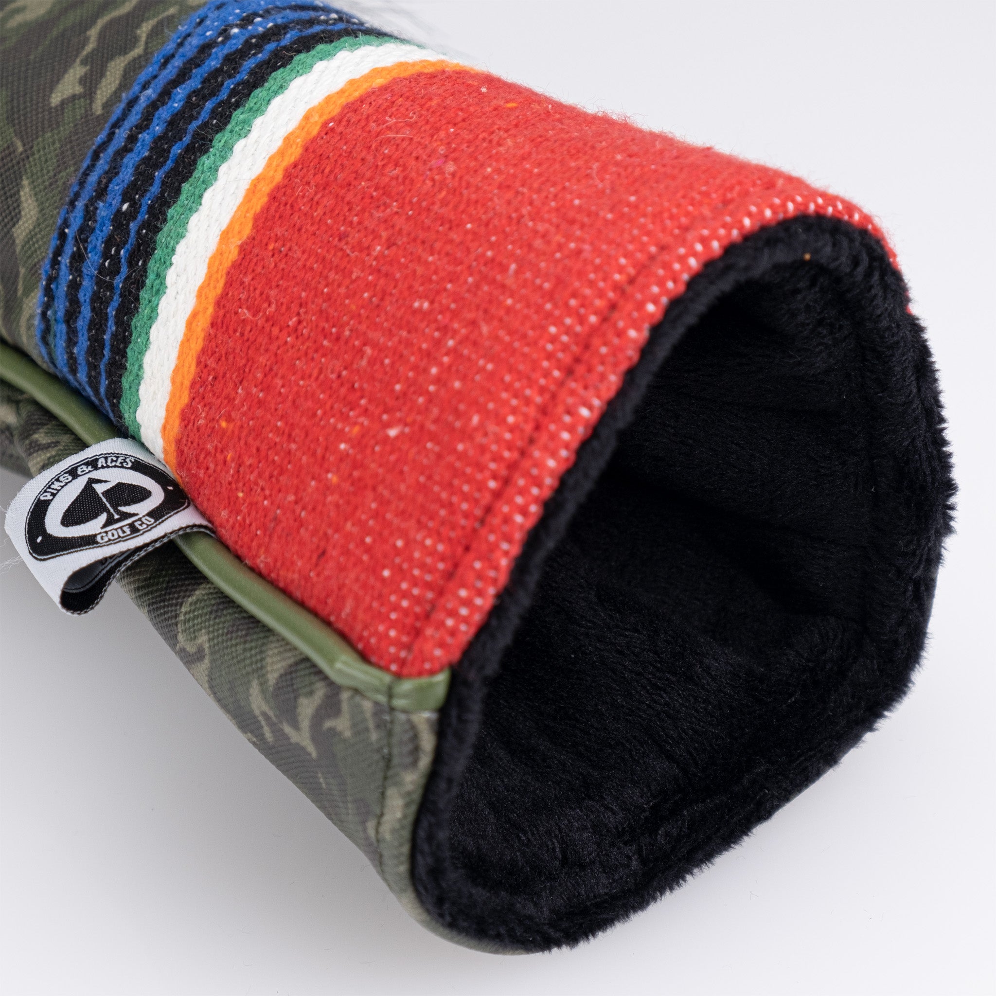 Colorful, bold golf headcover with red, black, green, white, blue, and orange stripes, featuring a textured fabric exterior.