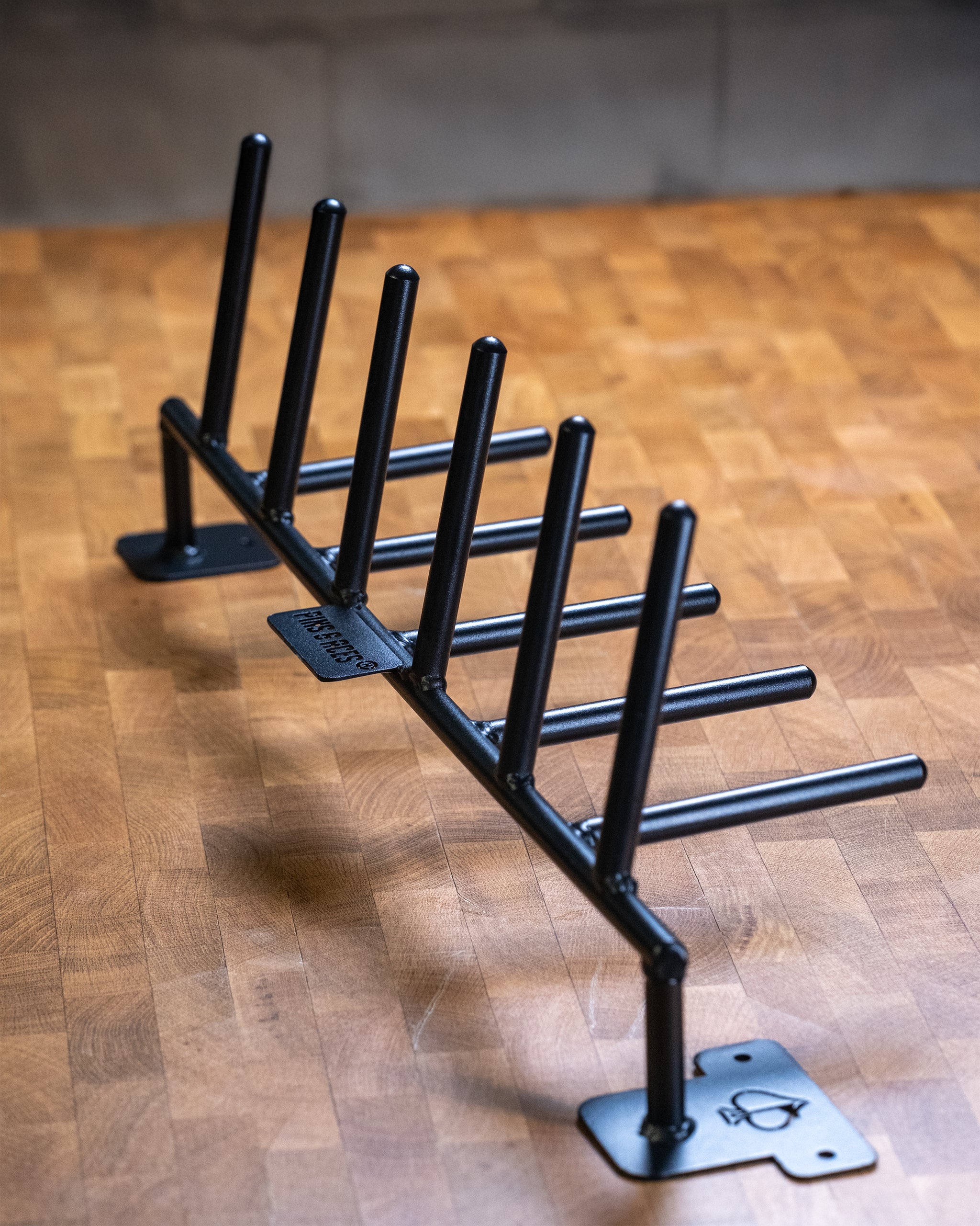 Compact Headcover Rack displayed on a wooden table, showcasing its sleek design and functionality for organizing golf headcovers.