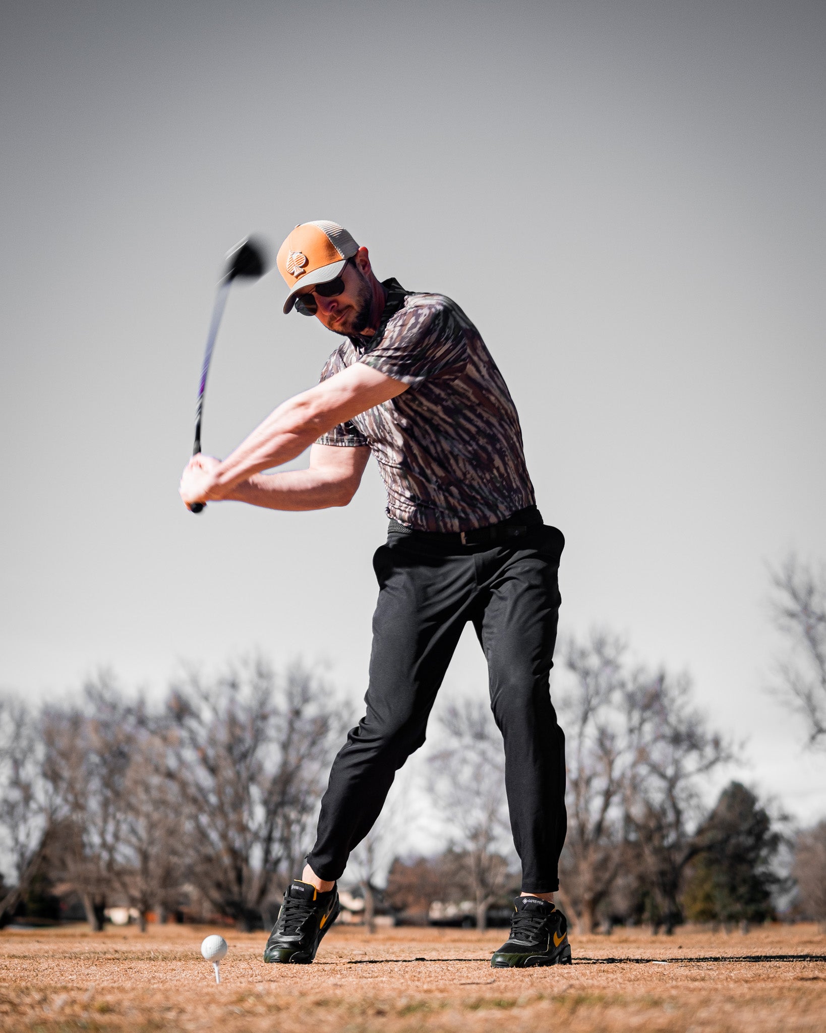 Realtree Original Polo, featuring a camo pattern in shades of green and brown, displayed on a white background.