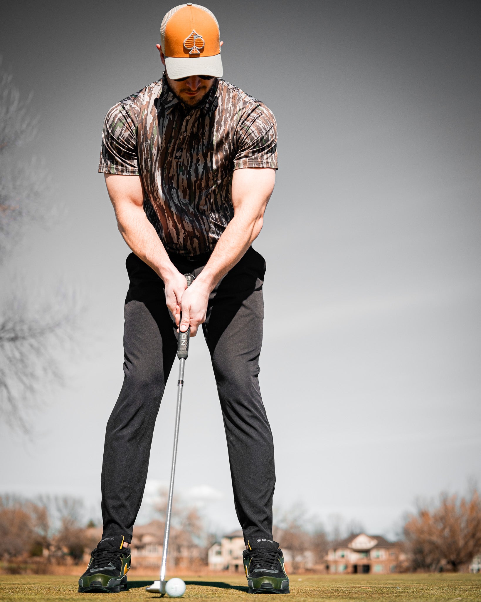 Realtree Original Polo featuring camouflage design, short sleeves, and collar, displayed against a neutral background.