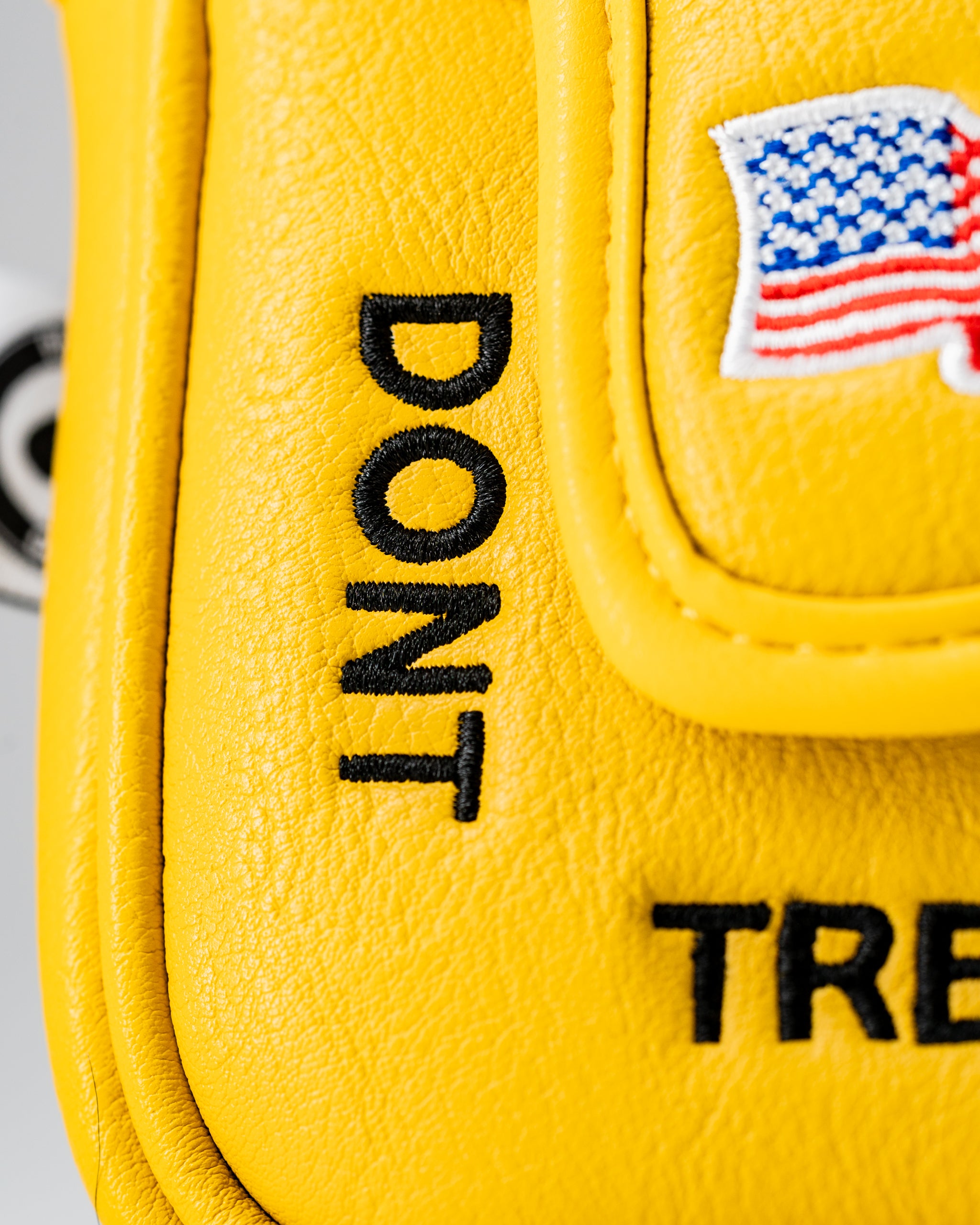 Bright yellow mallet putter cover featuring "Don't Tread on Me" text and an American flag emblem, perfect for bold golfers.