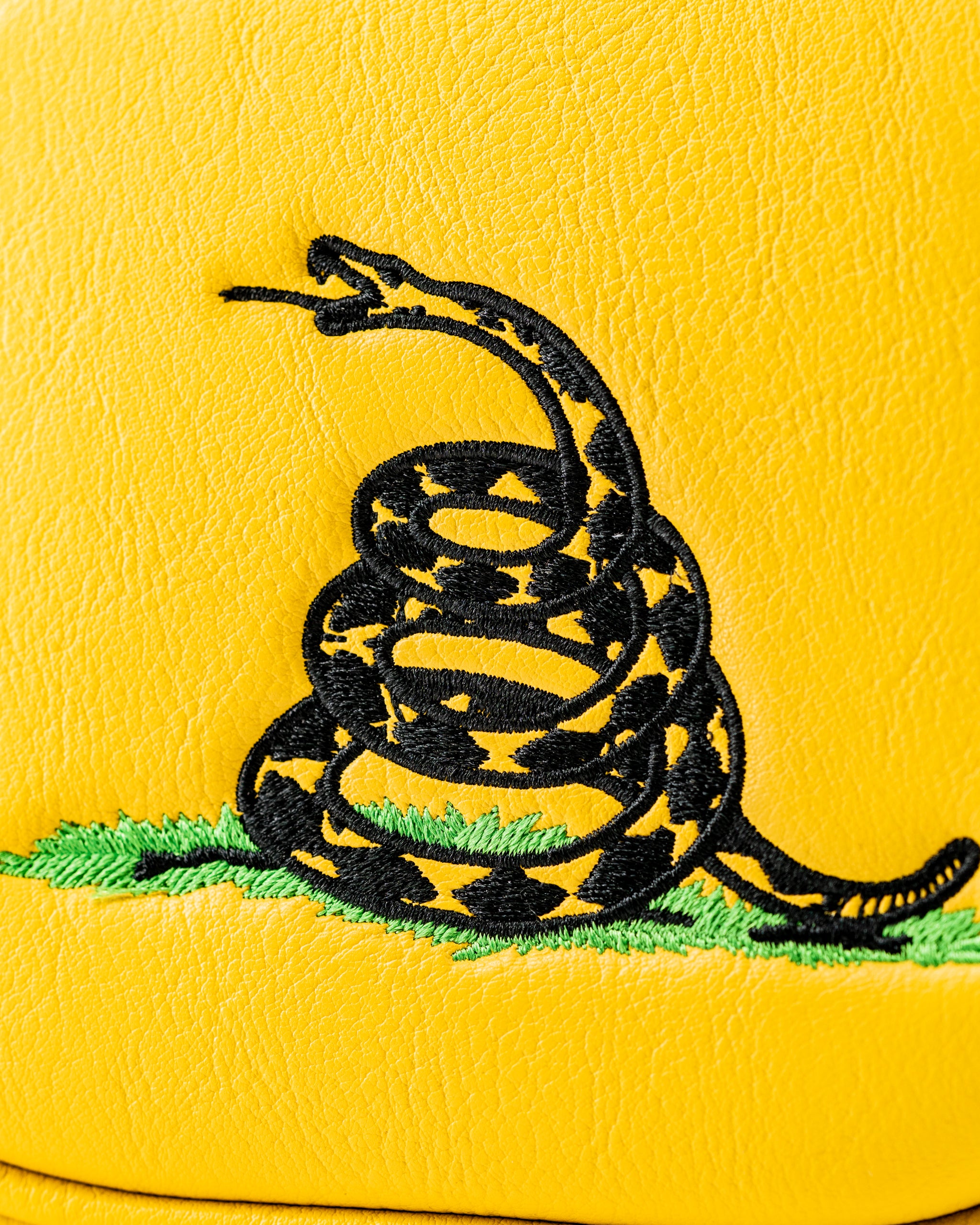 Bold yellow mallet putter cover featuring a black embroidered rattlesnake design, perfect for golfers seeking unique style.