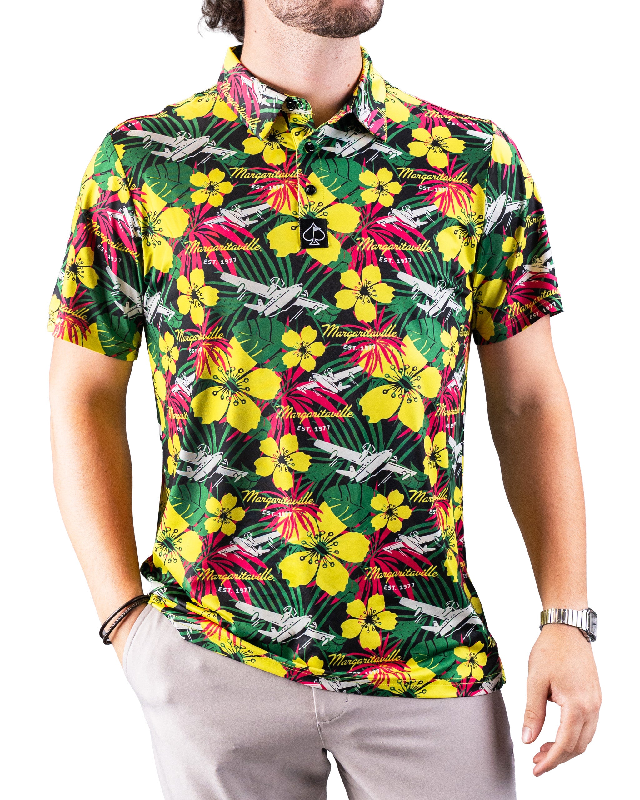 Bright tropical golf shirt with yellow hibiscus flowers, green leaves, pink accents, and white airplanes, featuring "Marga...