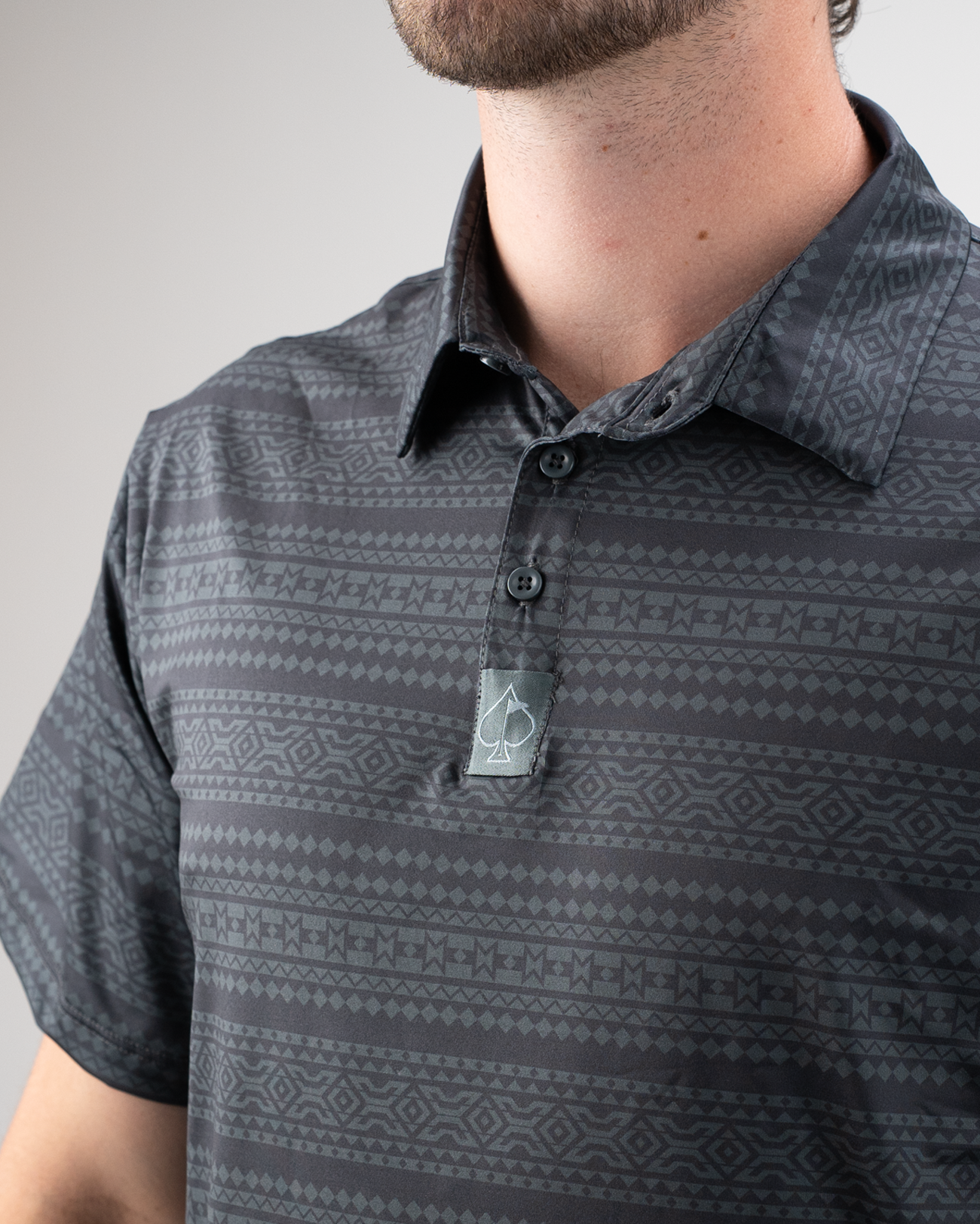 Men's Desert Geo golf shirt featuring a stylish geometric pattern in shades of gray and a button-up collar.