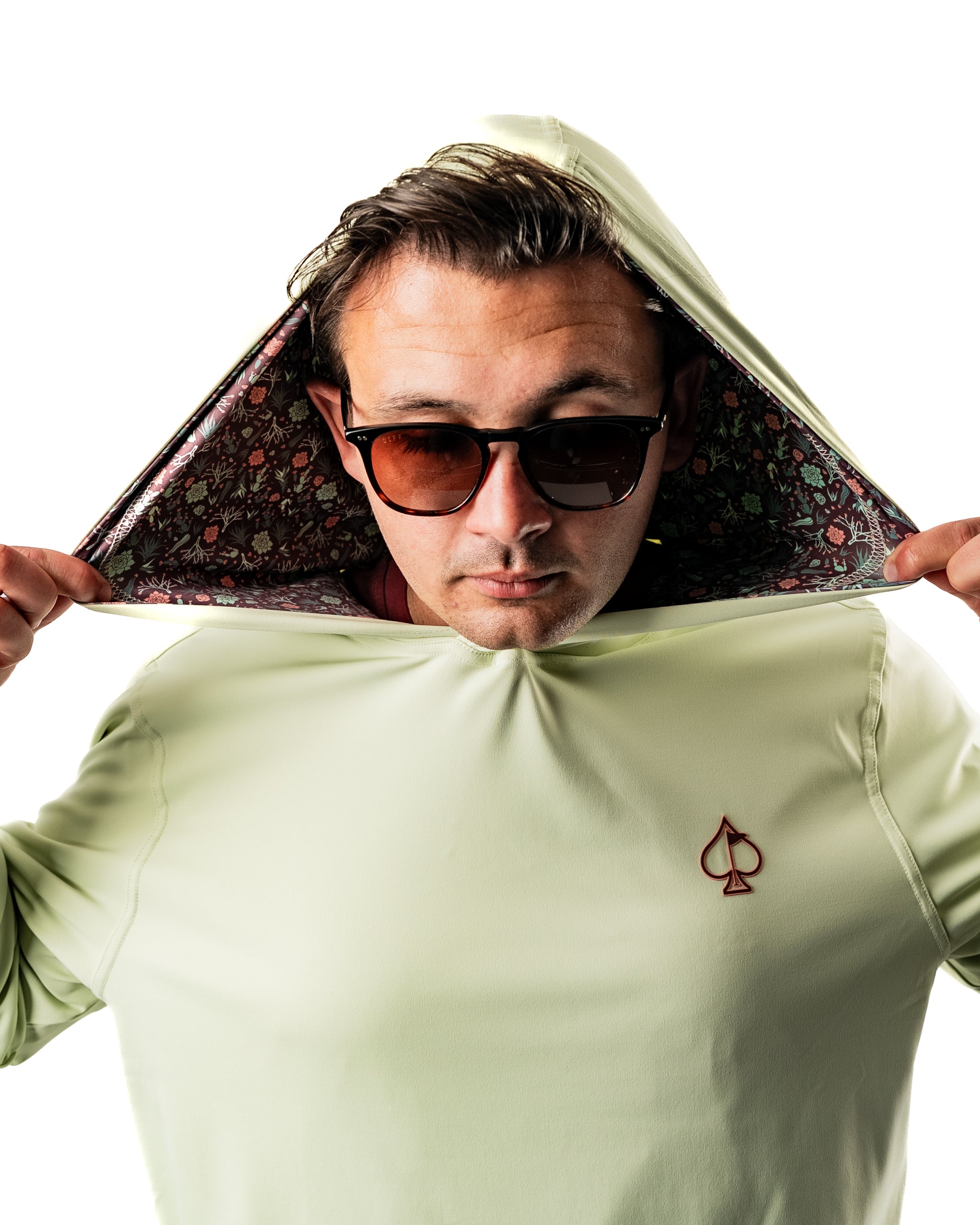 Man wearing a Desert Sage performance golf hoodie with a patterned interior, showcasing a stylish and sporty look.