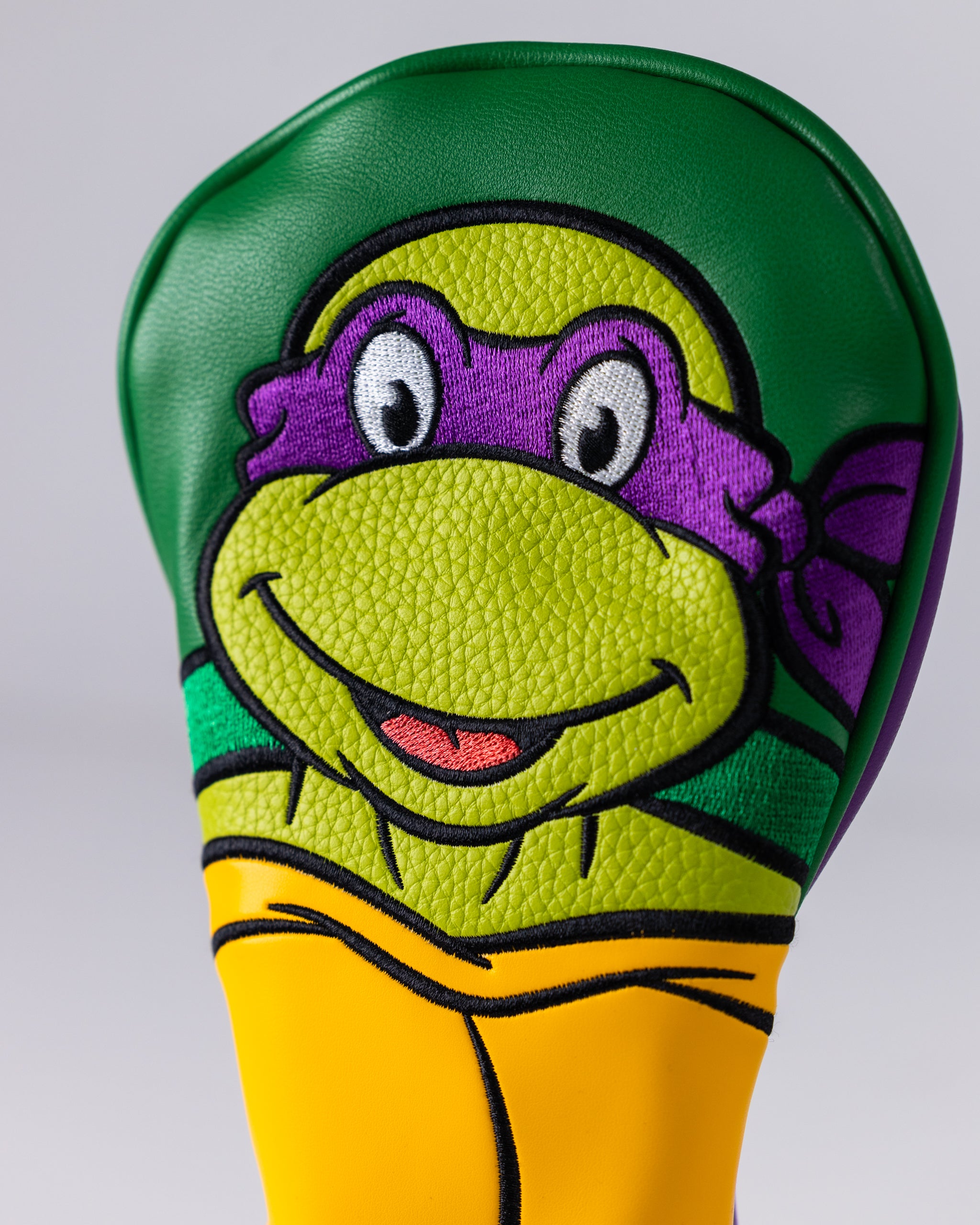 TMNT Donatello Fairway Cover in purple with turtle design, featuring Donatello's signature weapon, a bo staff, for golf clubs.
