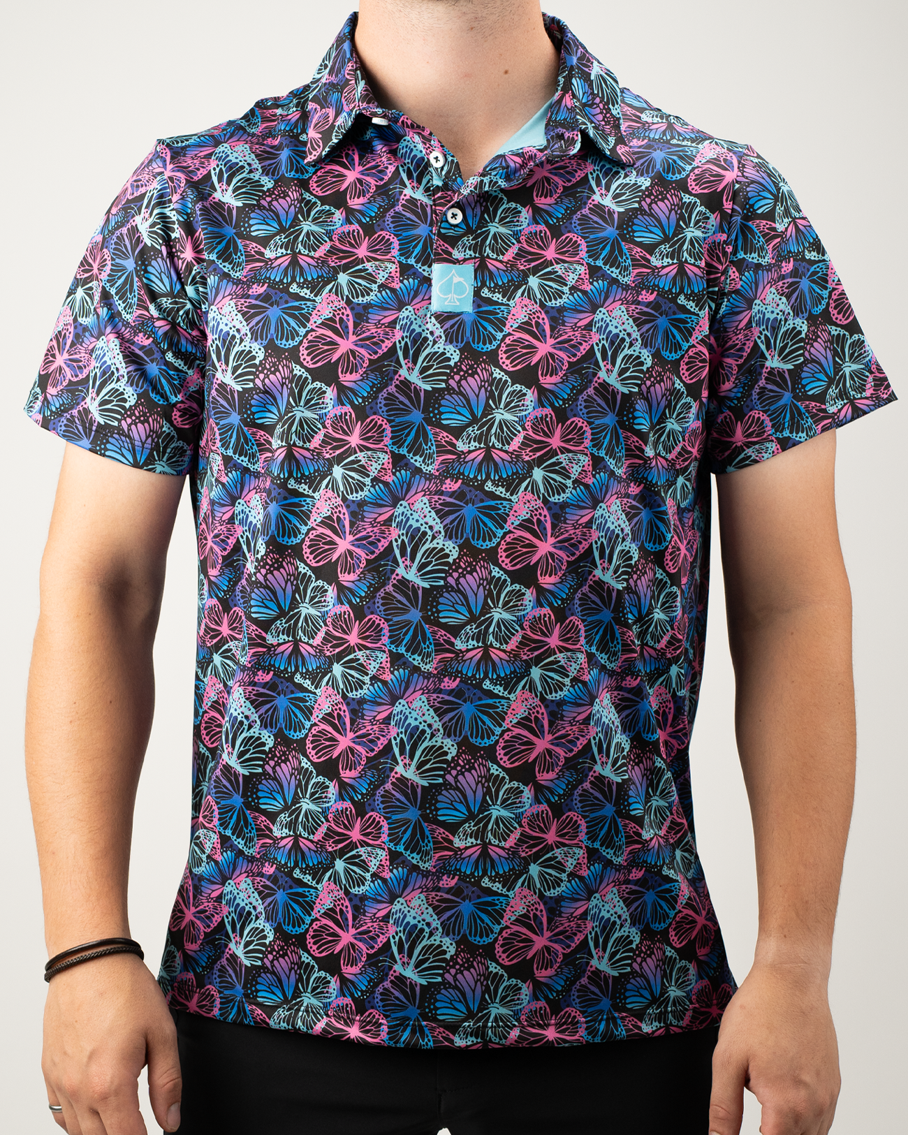 Men's golf shirt featuring a vibrant electric butterfly pattern in pink, blue, and black, perfect for a bold on-course look.