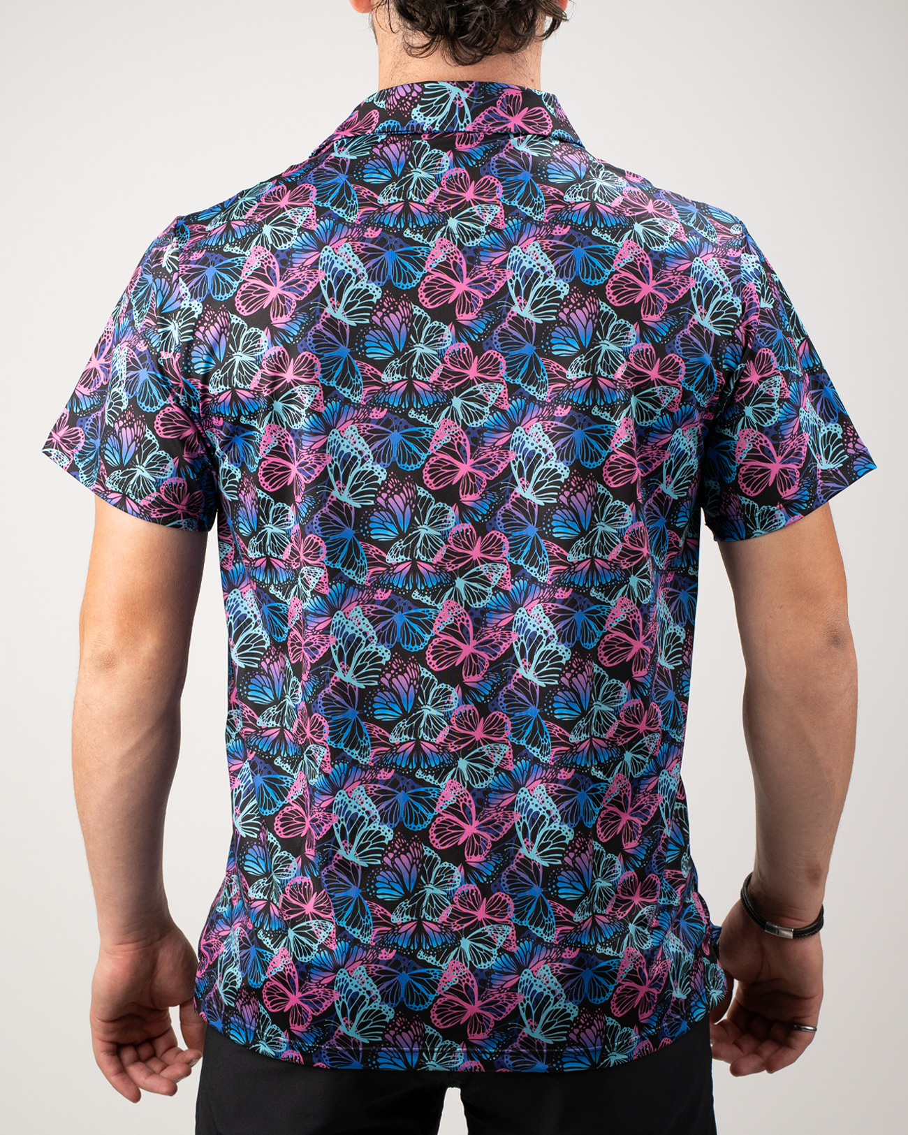 Men's short-sleeve shirt featuring a vibrant butterfly pattern in blue, pink, and purple against a dark background.