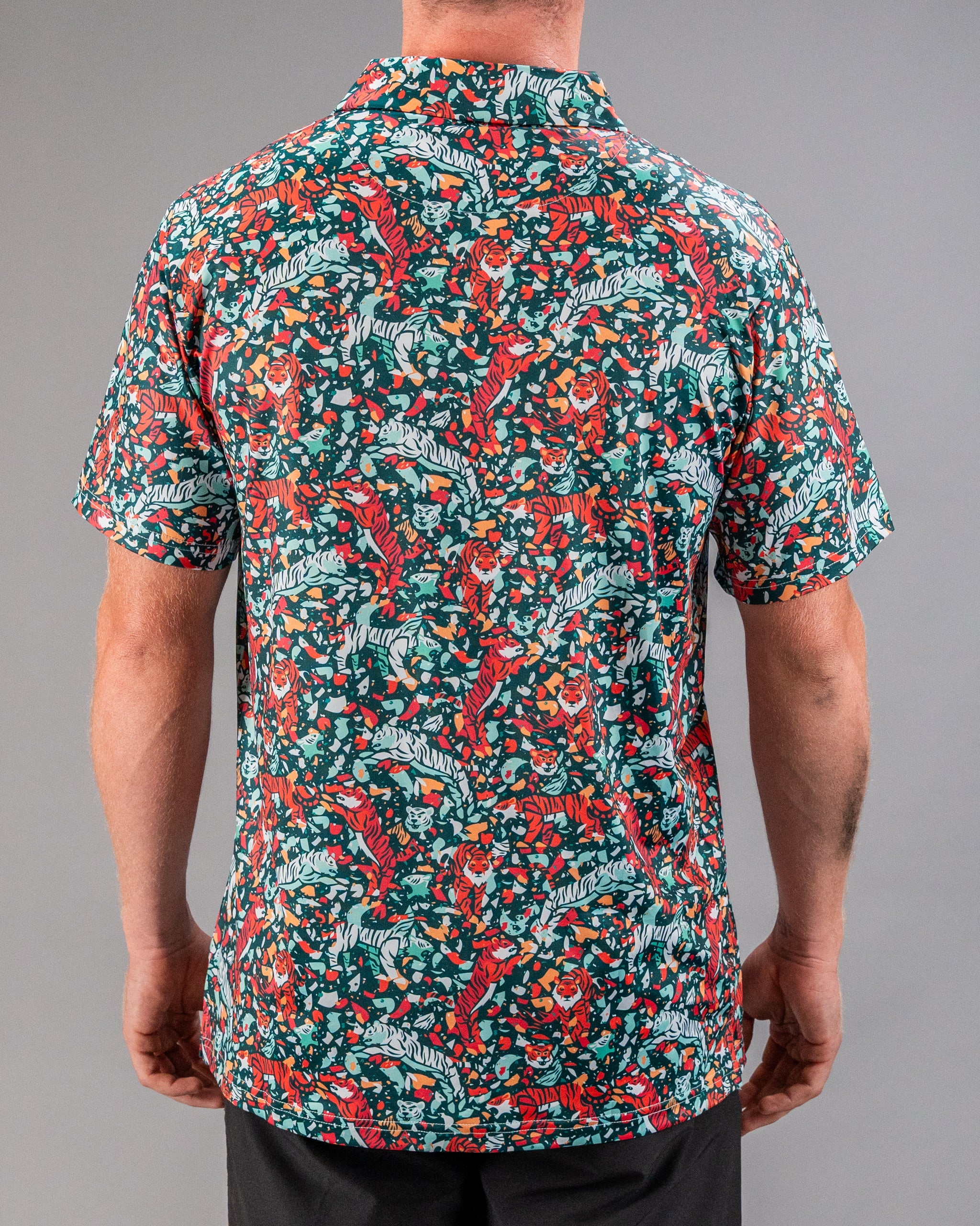 Bold golf shirt featuring a vibrant teal background with a playful tiger and floral pattern, ideal for standout style on the course.