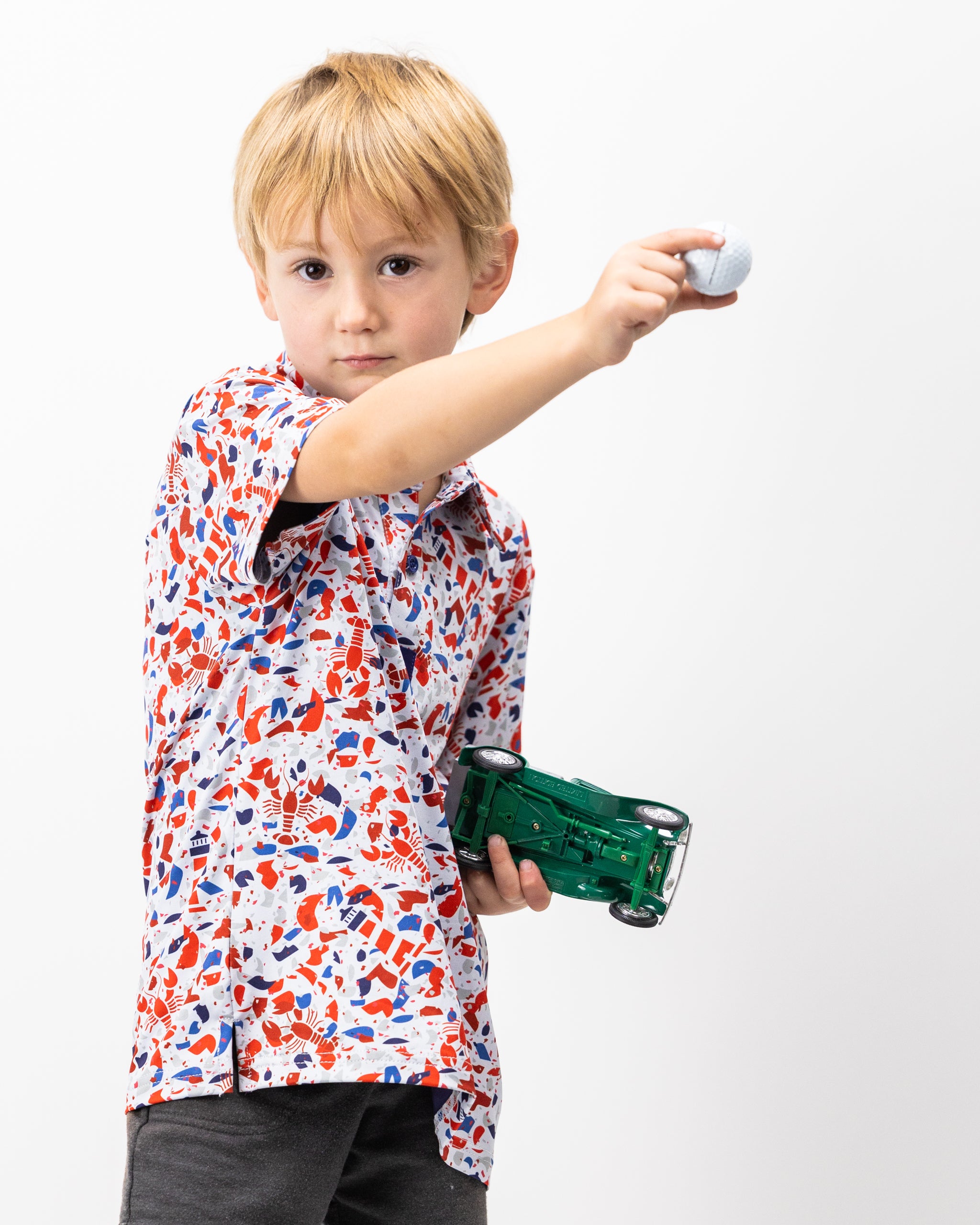 Youth Lobster Shatter polo shirt in vibrant red with a playful lobster graphic on the front.