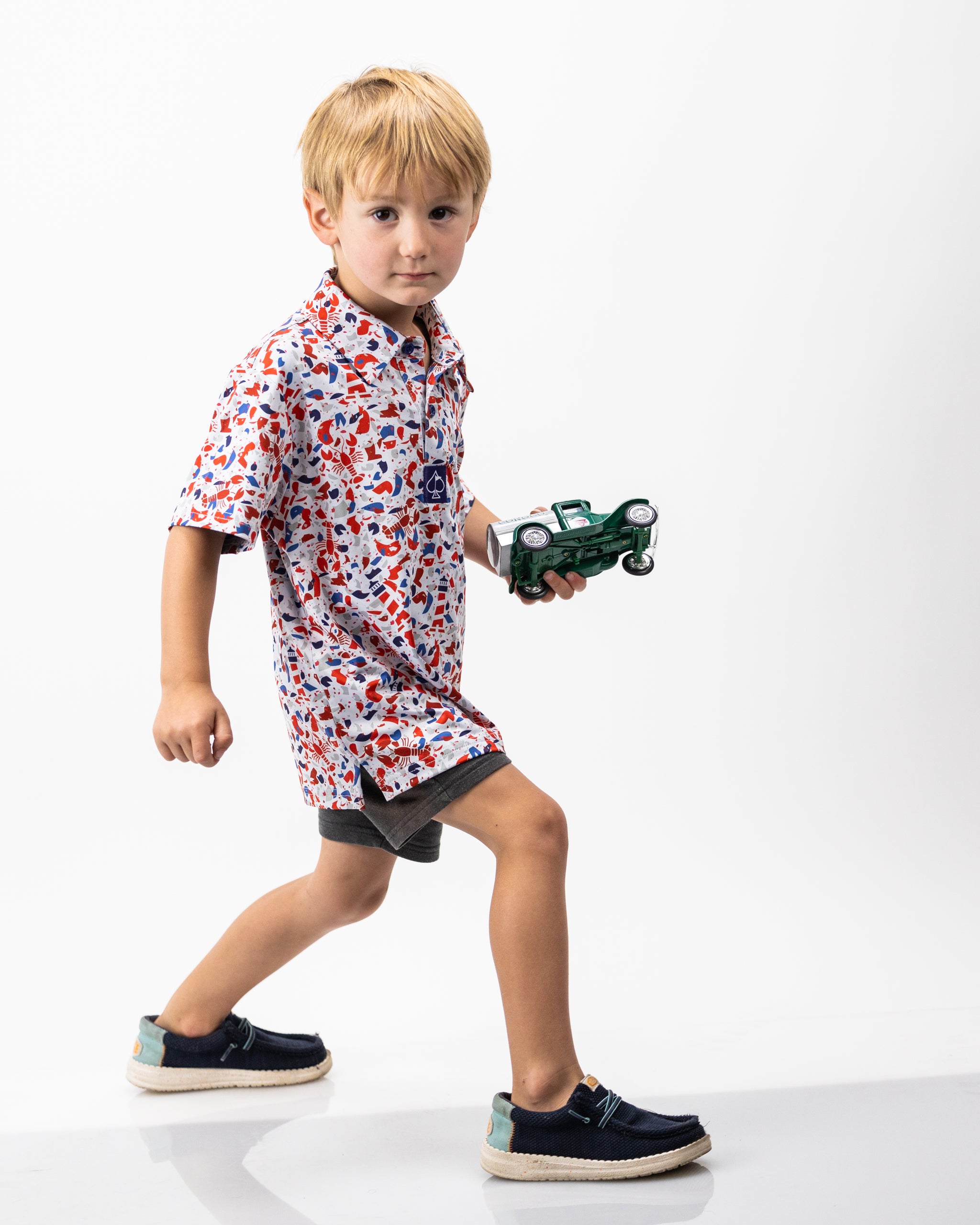 Youth Lobster Shatter graphic polo shirt in vibrant colors, featuring a playful lobster design.