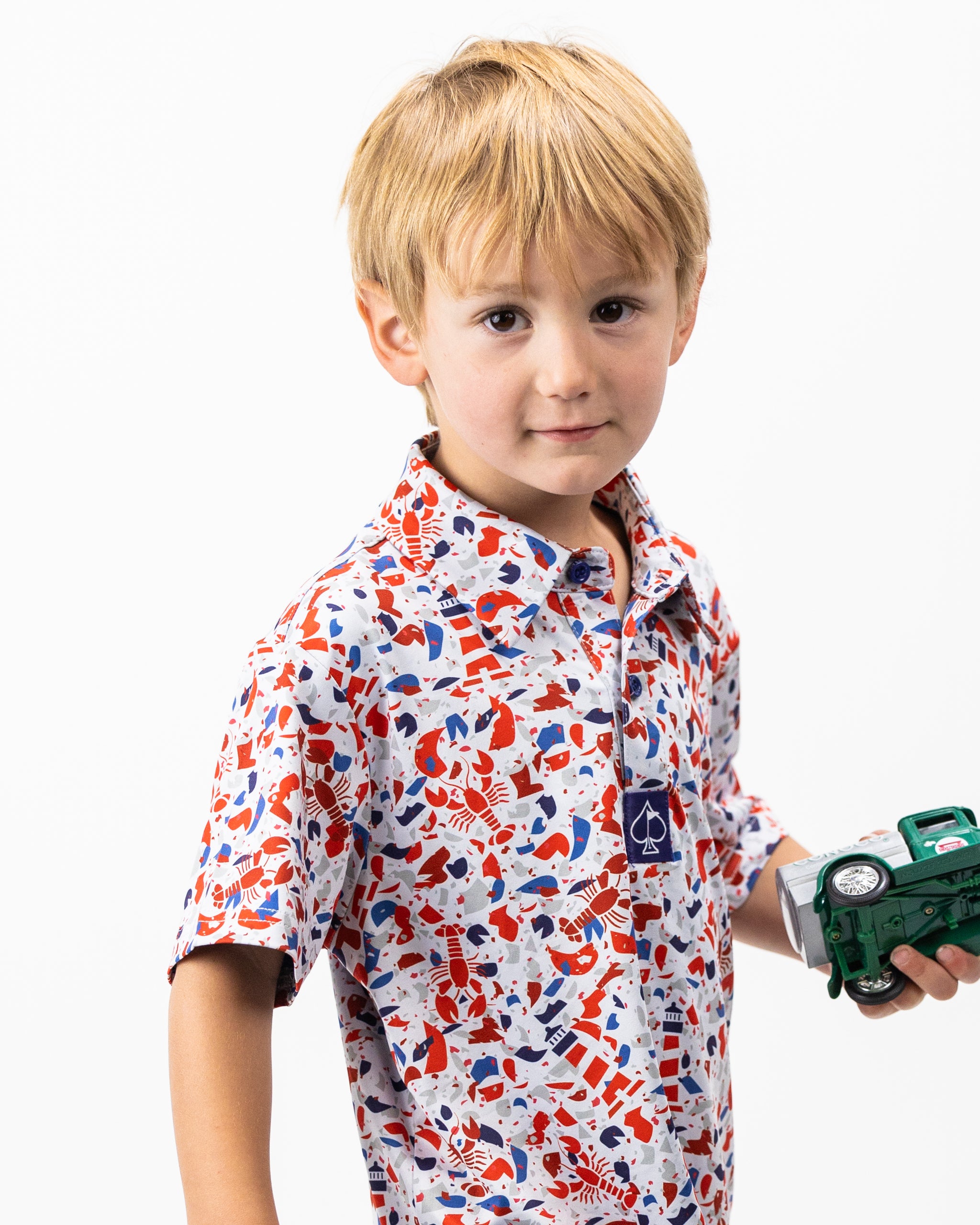 Youth Lobster Shatter polo shirt in vibrant orange with a playful lobster print, suitable for casual summer wear.