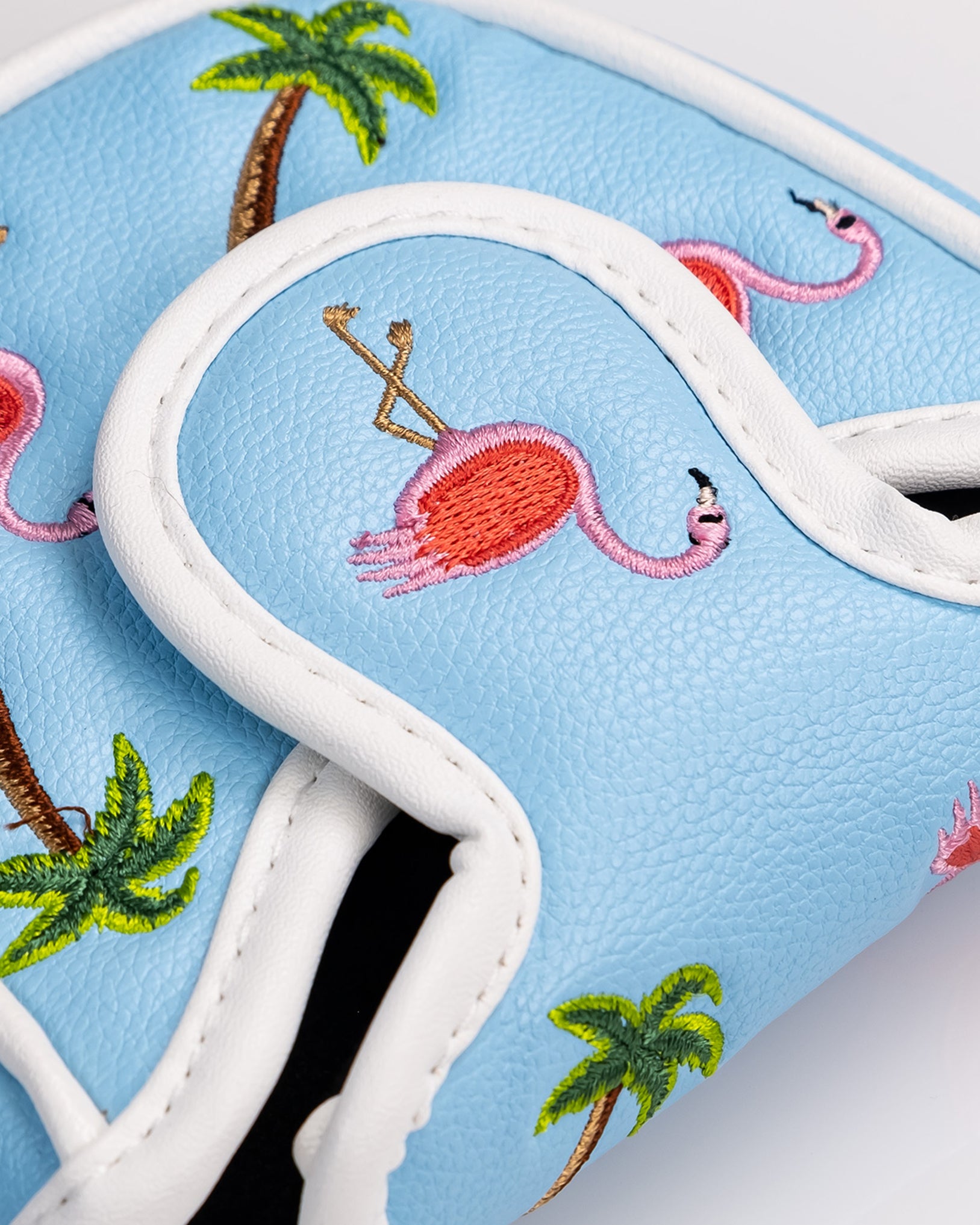 Embossed light blue golf headcover with pink flamingos, palm trees, and white trim, perfect for bold golf style.