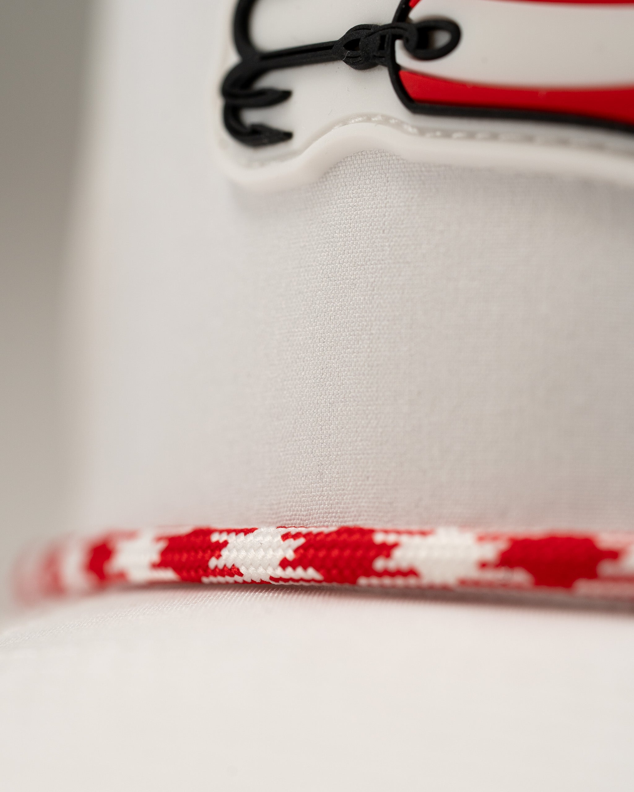 White perforated rope hat featuring a bold design and red and white detailing, perfect for stylish golfers.
