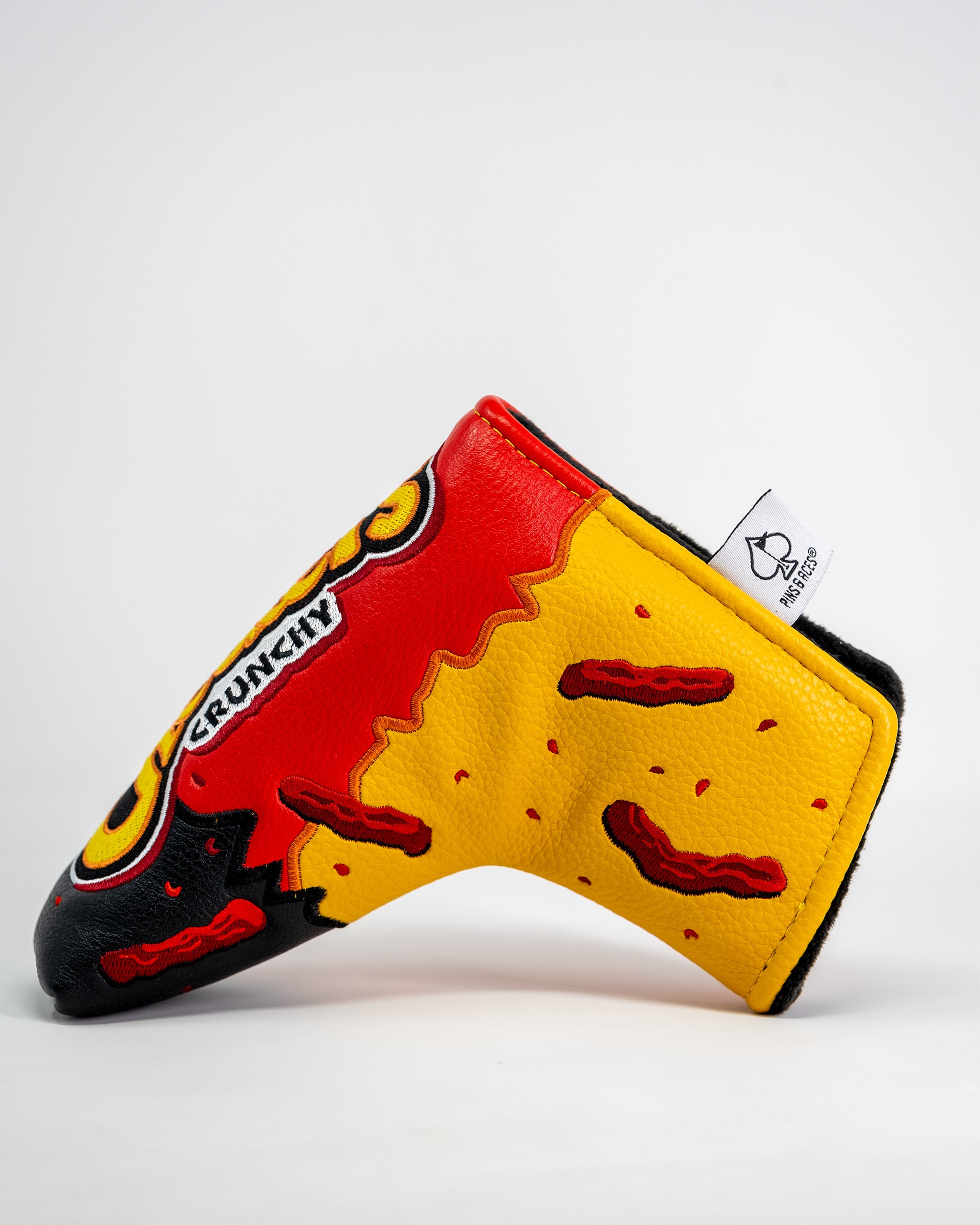 Cheddar cheese and bacon themed blade putter cover with bright red, yellow, and black colors, featuring a spicy hot cheetos design.