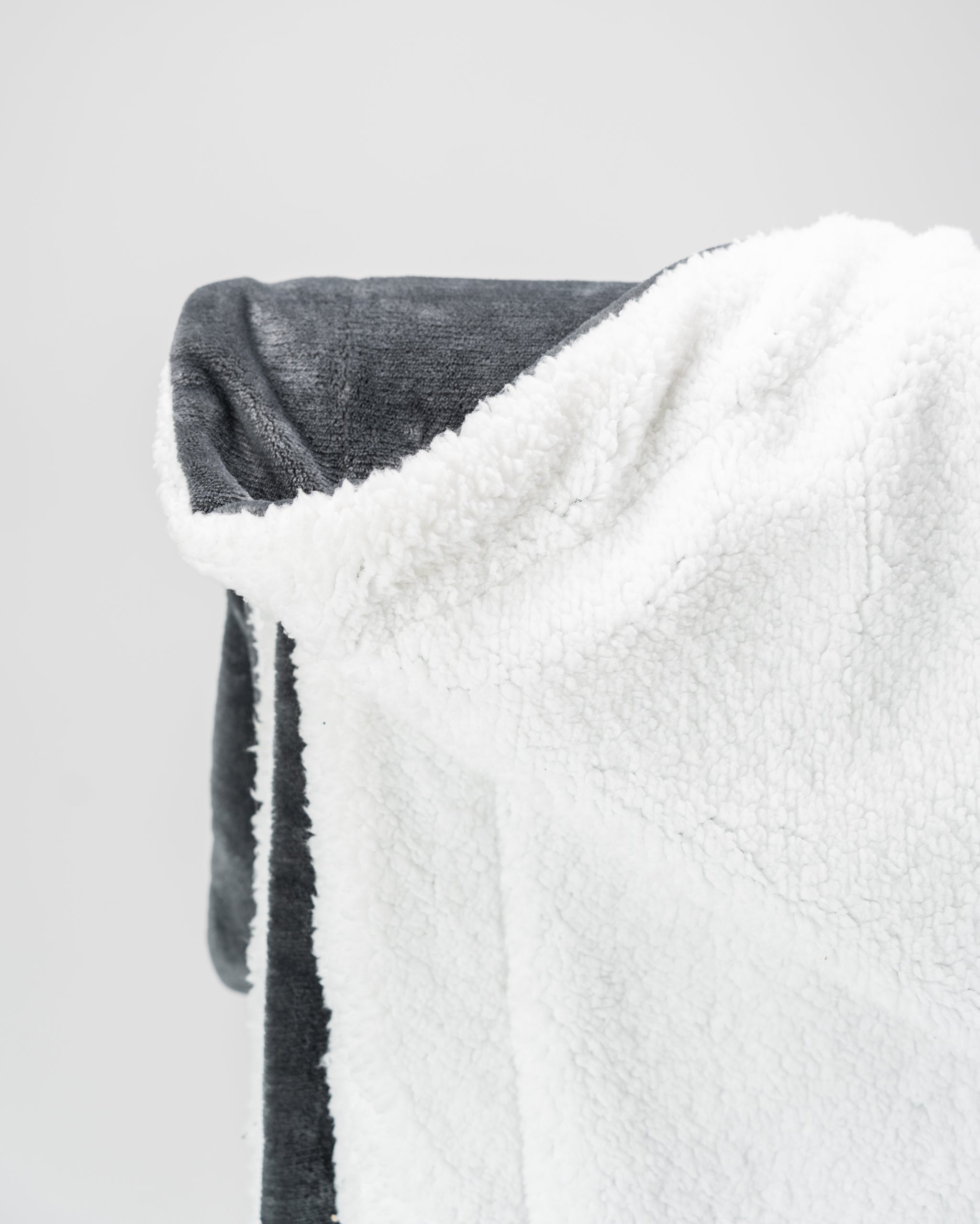 Bogey Blanket in dark gray, featuring a soft fleece texture, folded neatly on a white background.
