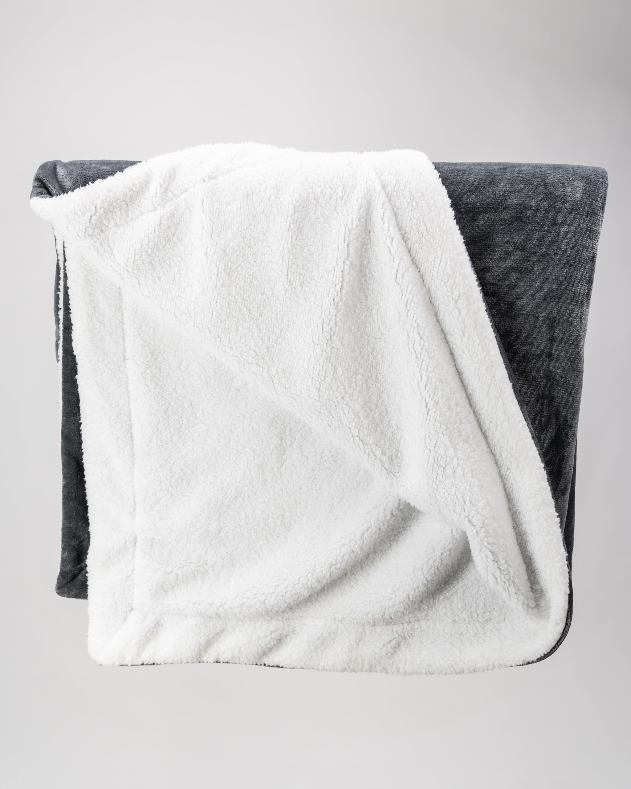 Dark gray Bogey Blanket made from soft fleece, folded neatly with a subtle texture. Ideal for cozying up at home.