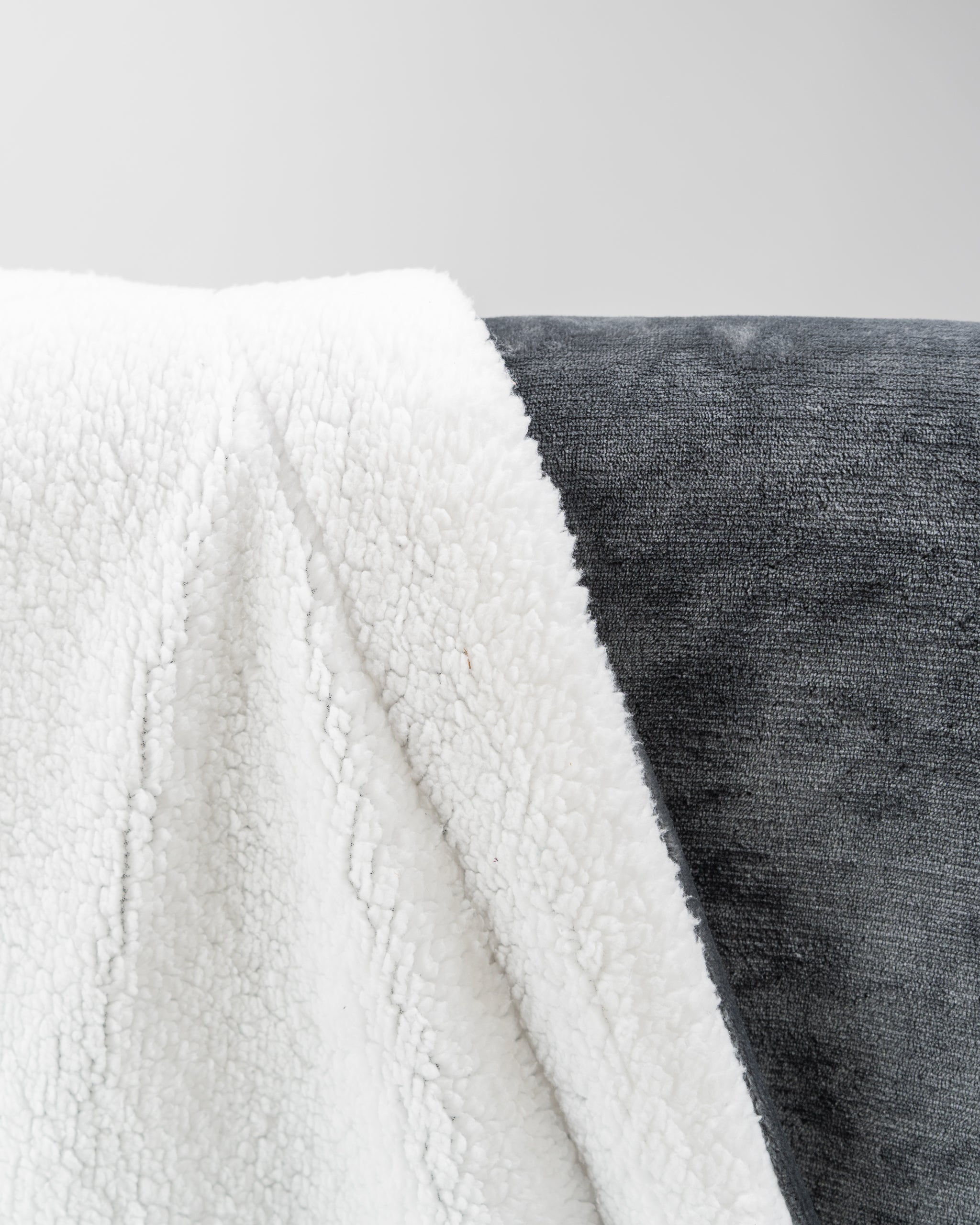 Dark gray Bogey Blanket made of soft fleece, folded neatly on a surface.
