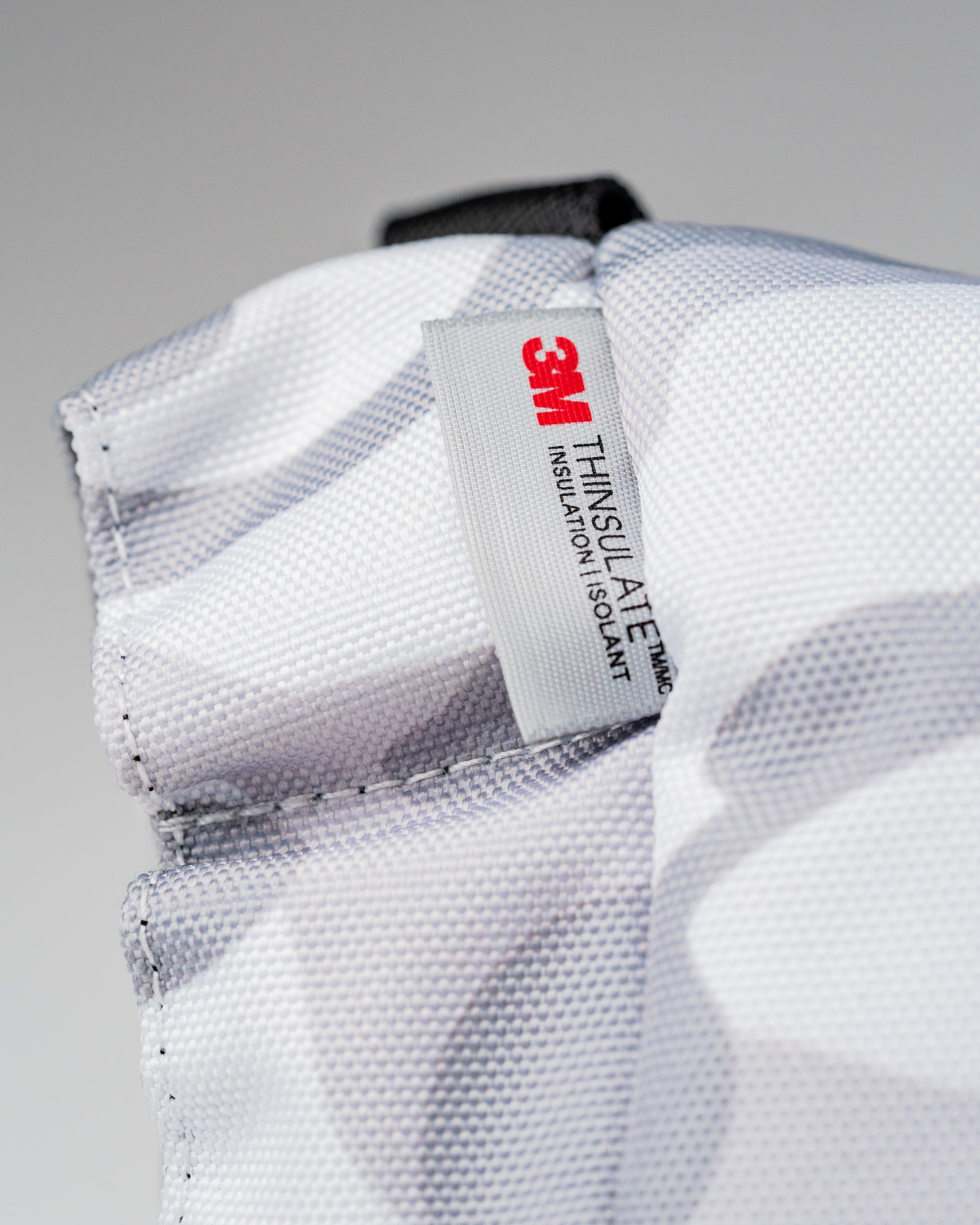 Close-up of the Pins and Aces X G-Tech Electric Hand Warmer showing 3M Thinsulate insulation label for warmth and comfort.