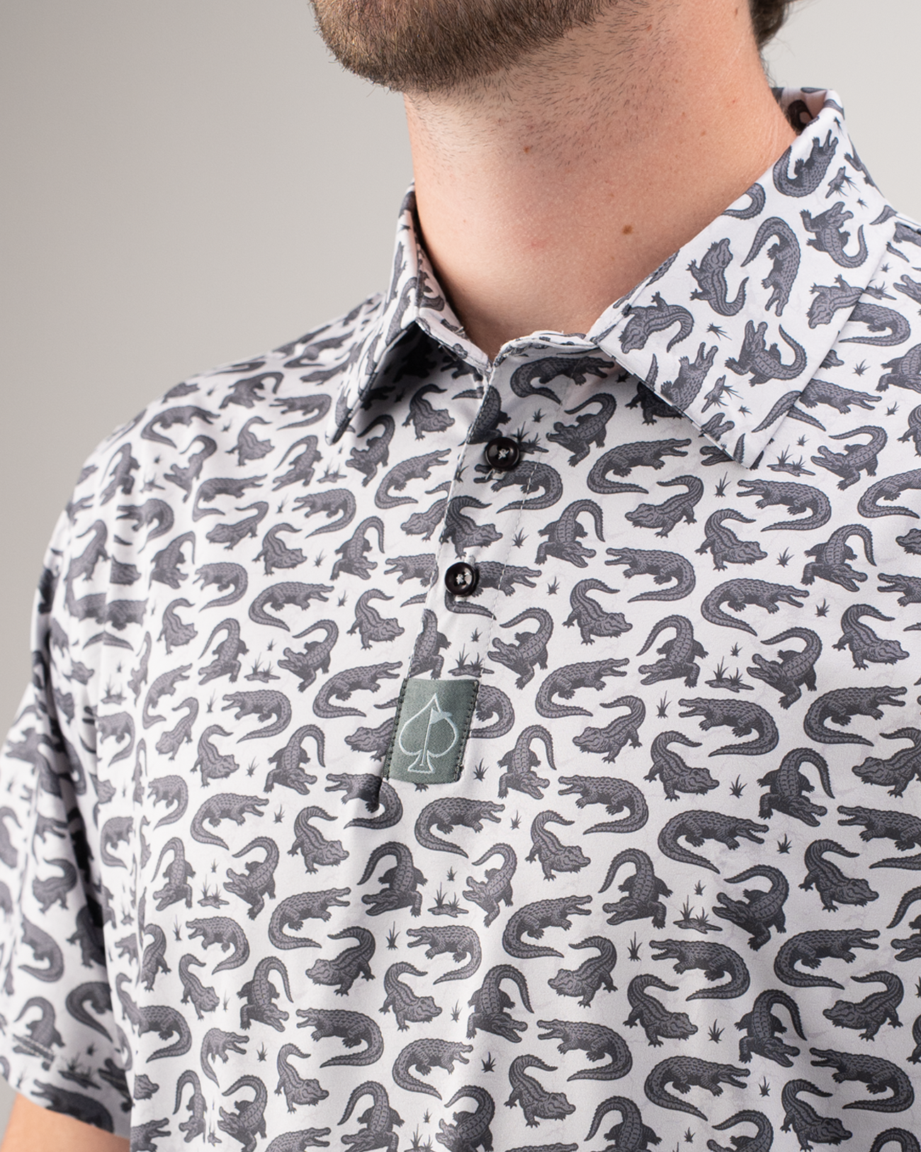 Men's golf polo featuring an alligator print in black and white, designed for a stylish and bold look on the course.
