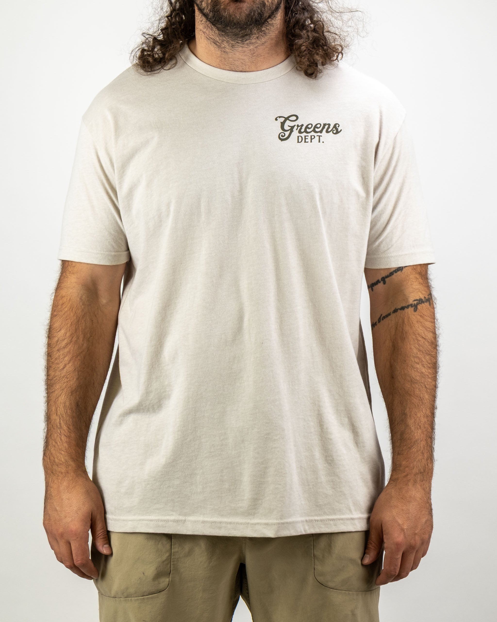 Men's beige tee shirt featuring "Greens Dept." text, designed for comfort and style on and off the golf course.