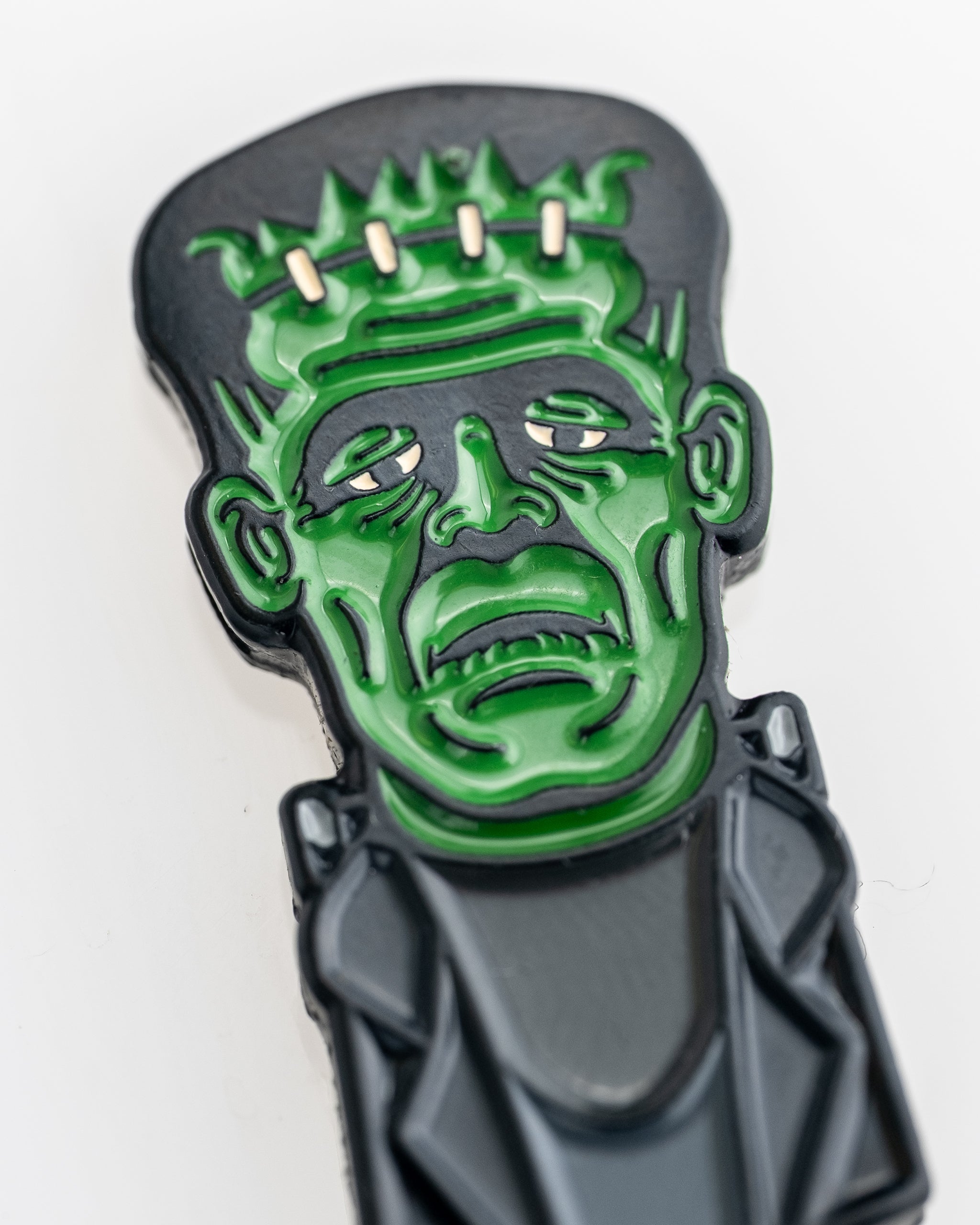 Frankenstein-themed golf ball marker featuring a colorful design with a cartoonish Frankenstein monster.