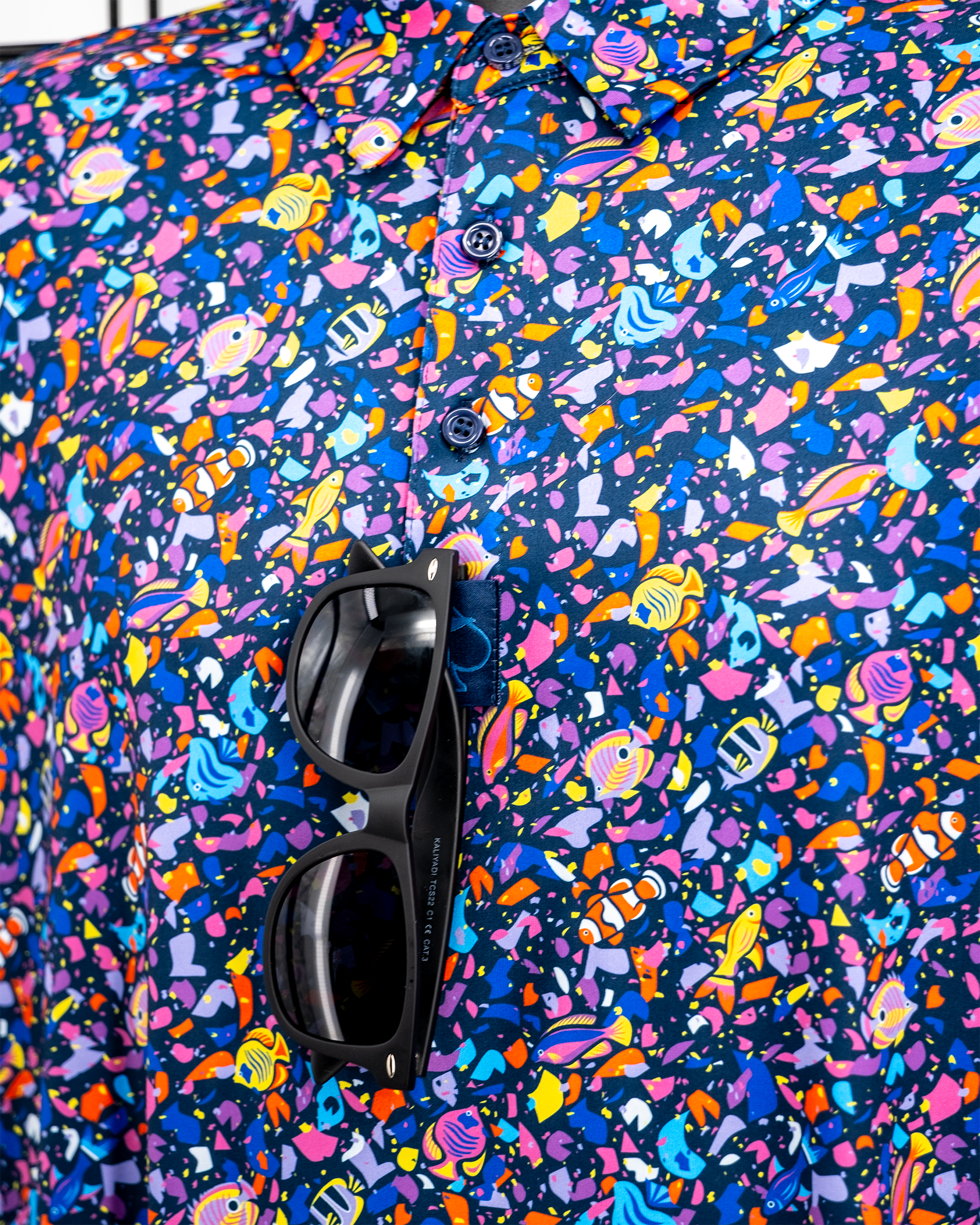 Alt text: Tropical Shatter cannabis concentrate in a jar with a vibrant, colorful background.