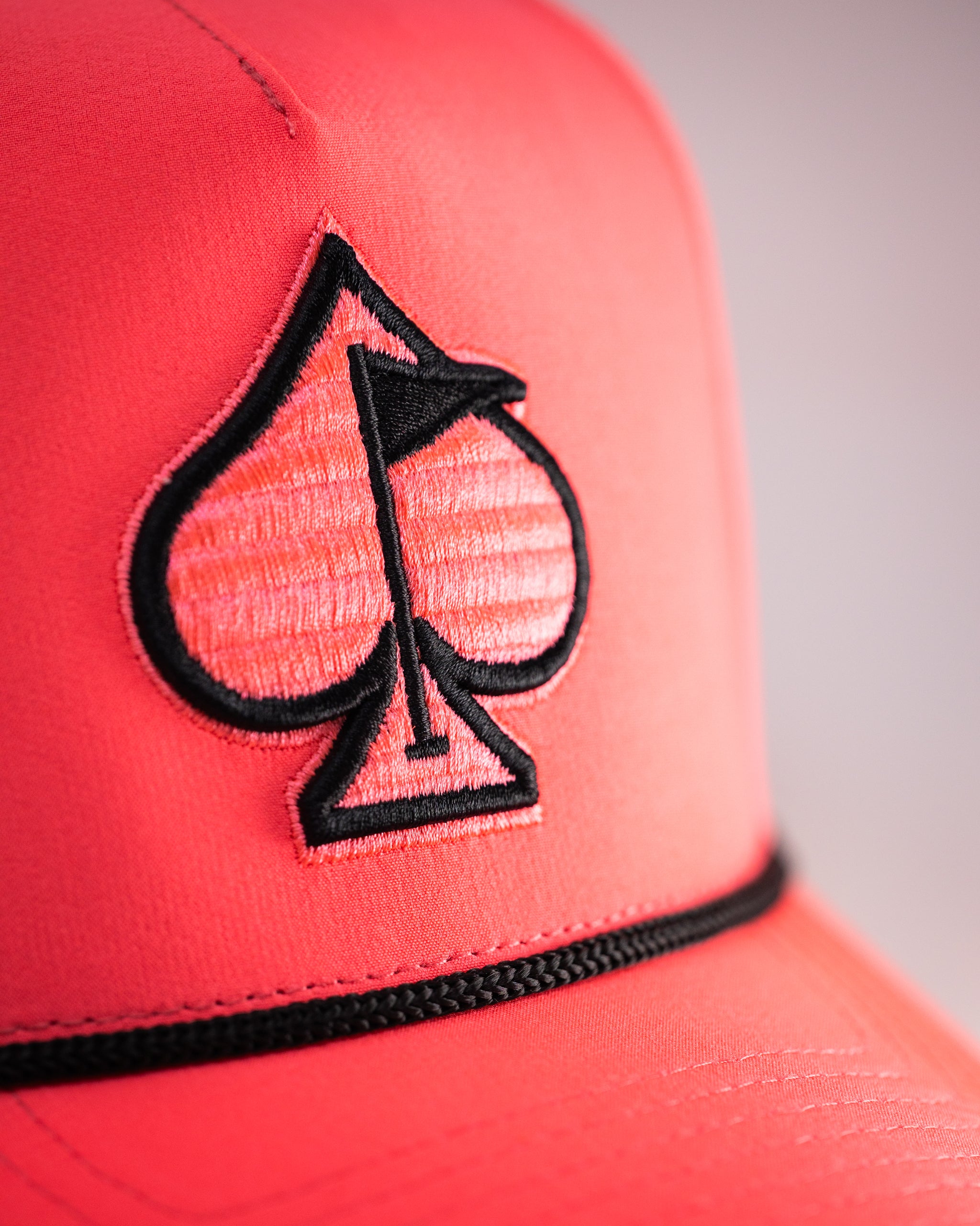 Perforated rope hat in highlighter pink with a stylish braided strap.