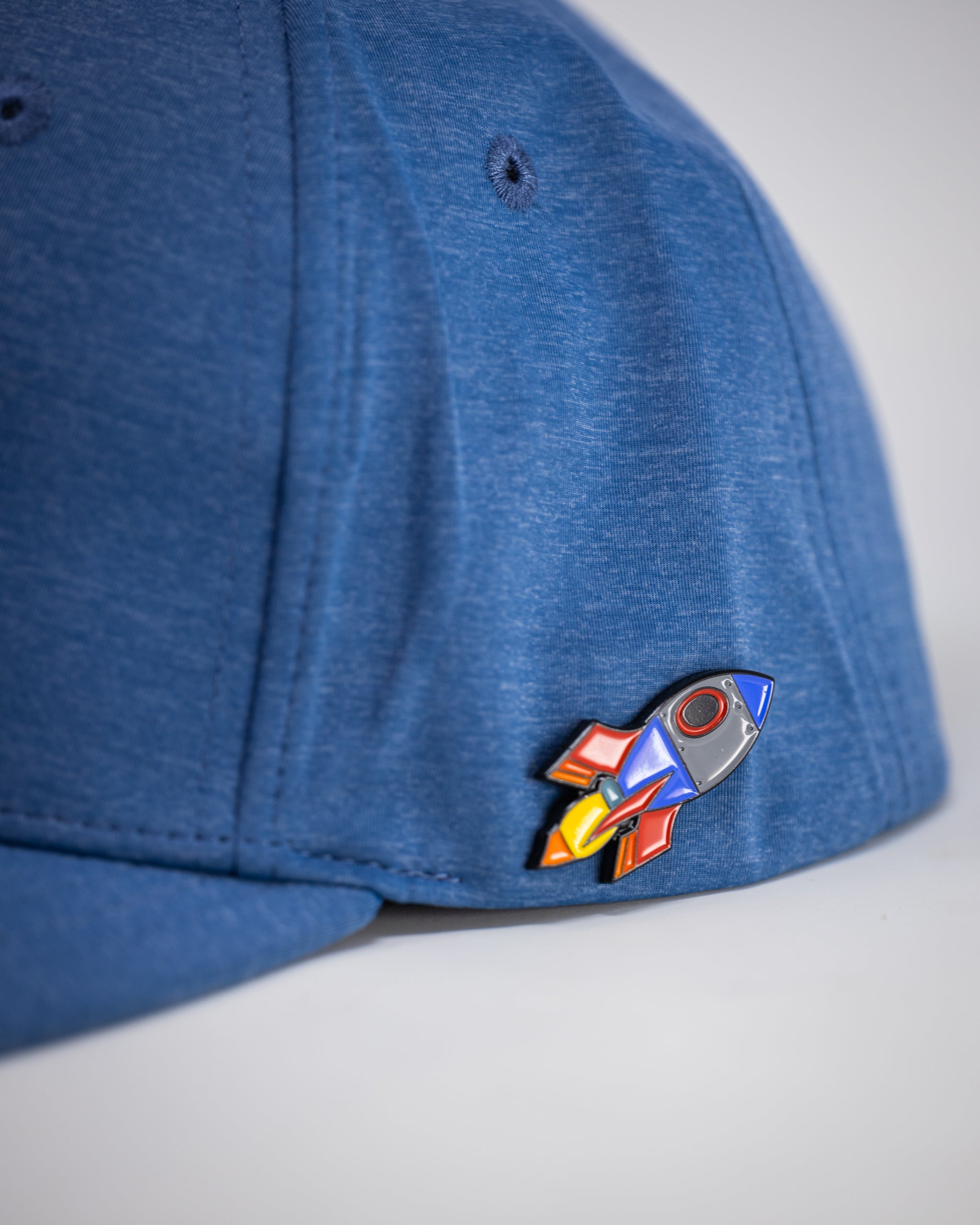 Performance Spade Hat in blue, featuring a sleek design and adjustable strap, perfect for outdoor activities.