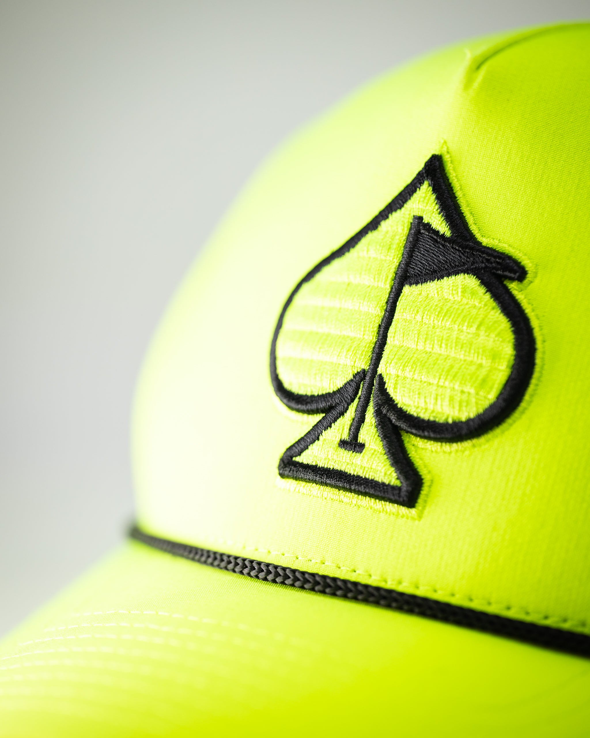 Perforated highlighter yellow rope hat with adjustable strap and ventilated design.