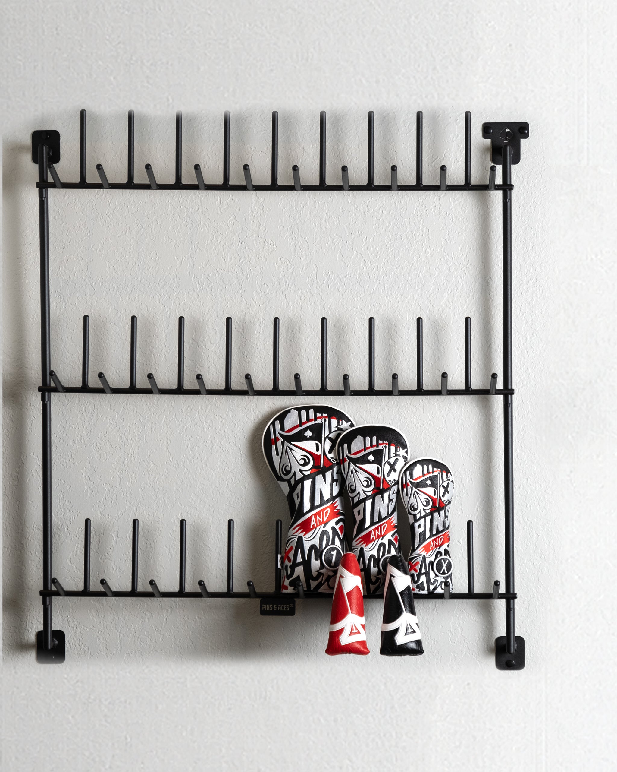 Metal headcover rack displaying organized golf headcovers in various colors.