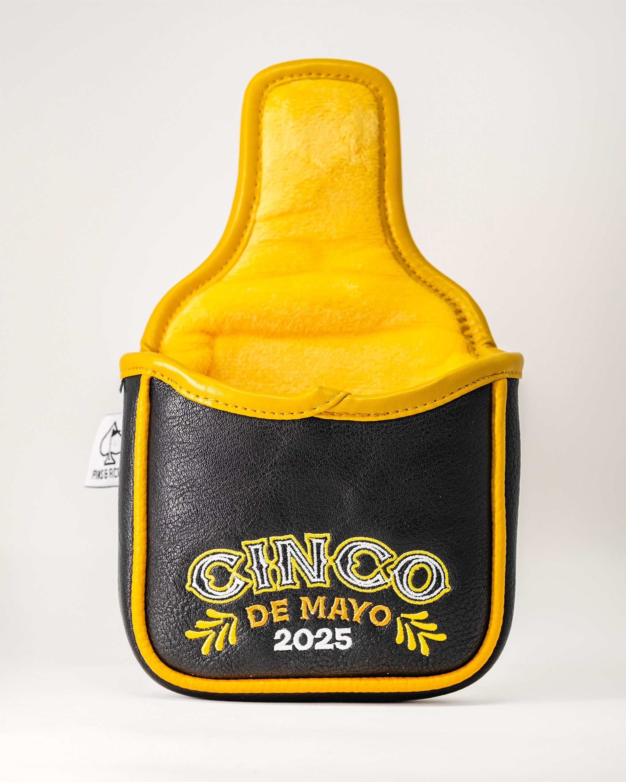 Lucha Libre mask-themed mallet putter cover with black exterior, yellow interior, and embroidered "Cinco de Mayo 2025" design.