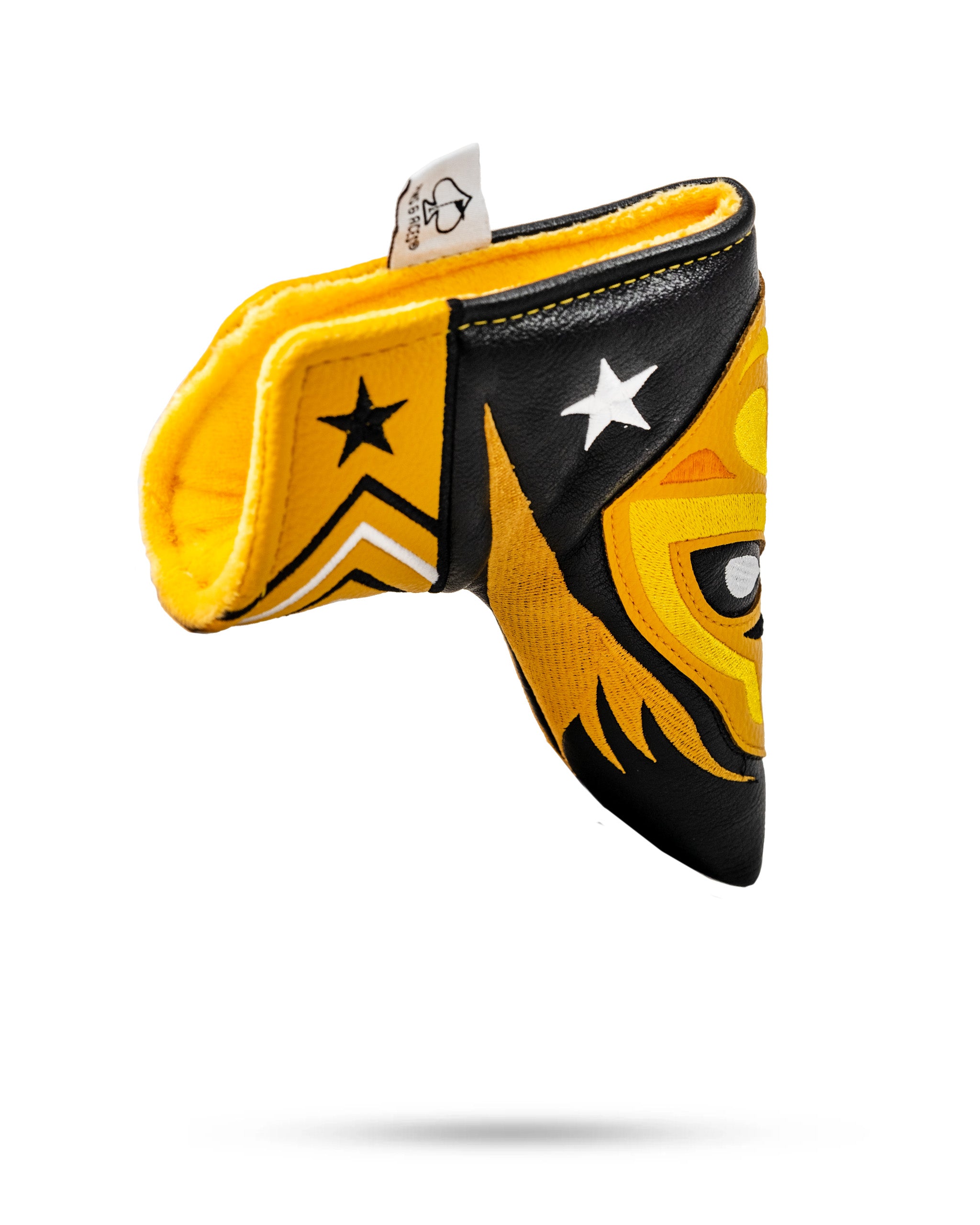 Lucha Libre mask-inspired Blade Putter Cover with bold yellow, black, and white star and face designs, shaped like a mask.