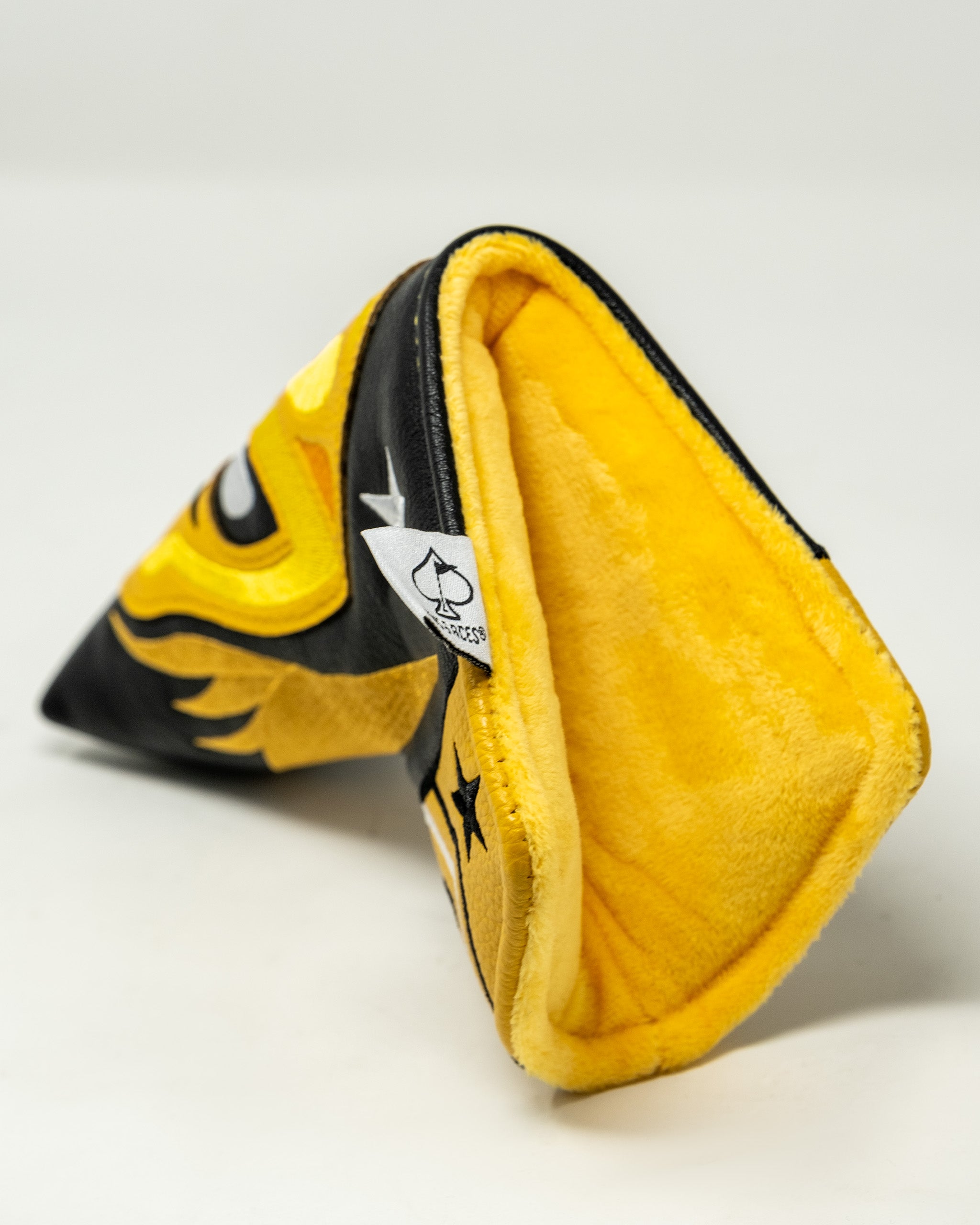 Lucha Libre mask-shaped blade putter cover with yellow and black fabric, soft interior, and detailed wrestling design.
