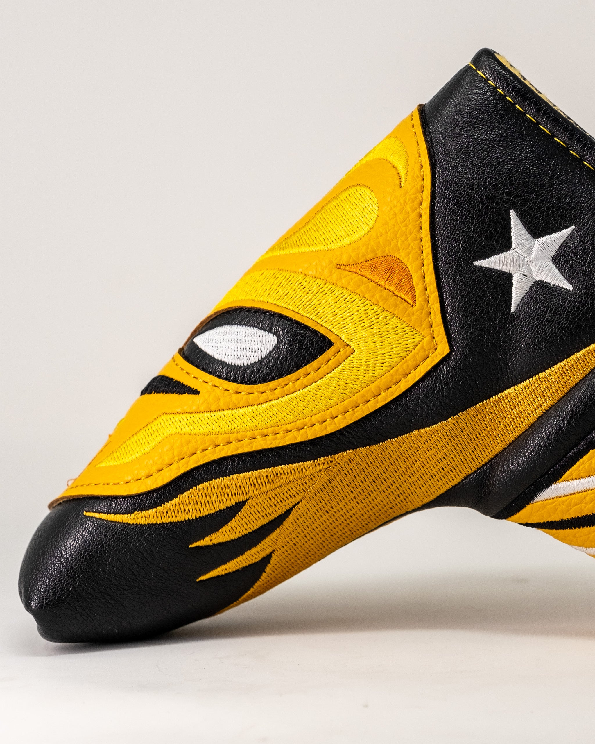 Lucha Libre mask-inspired Blade Putter Cover in yellow and black with star and eye details, designed for golf clubs.