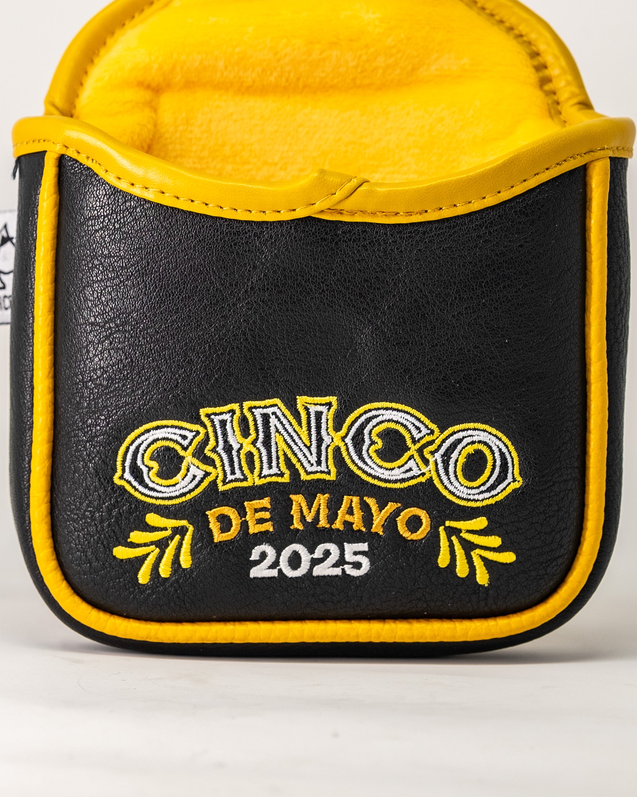 Lucha Libre mask-themed mallet putter cover with black and yellow design, embroidered "Cinco de Mayo 2025" text.