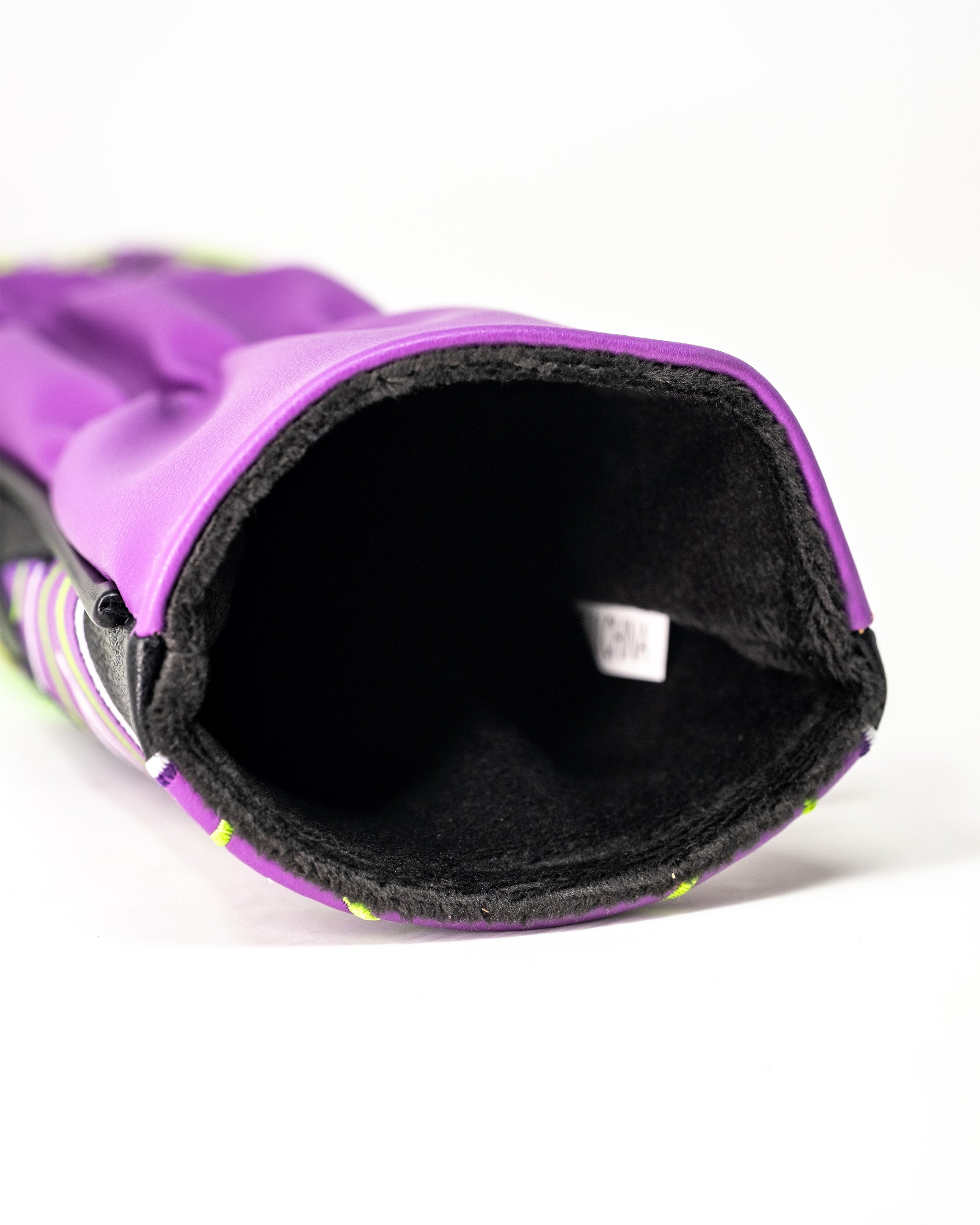 Close-up of a purple Lucha Libre mask-themed golf fairway cover with black interior lining and colorful striped accents.