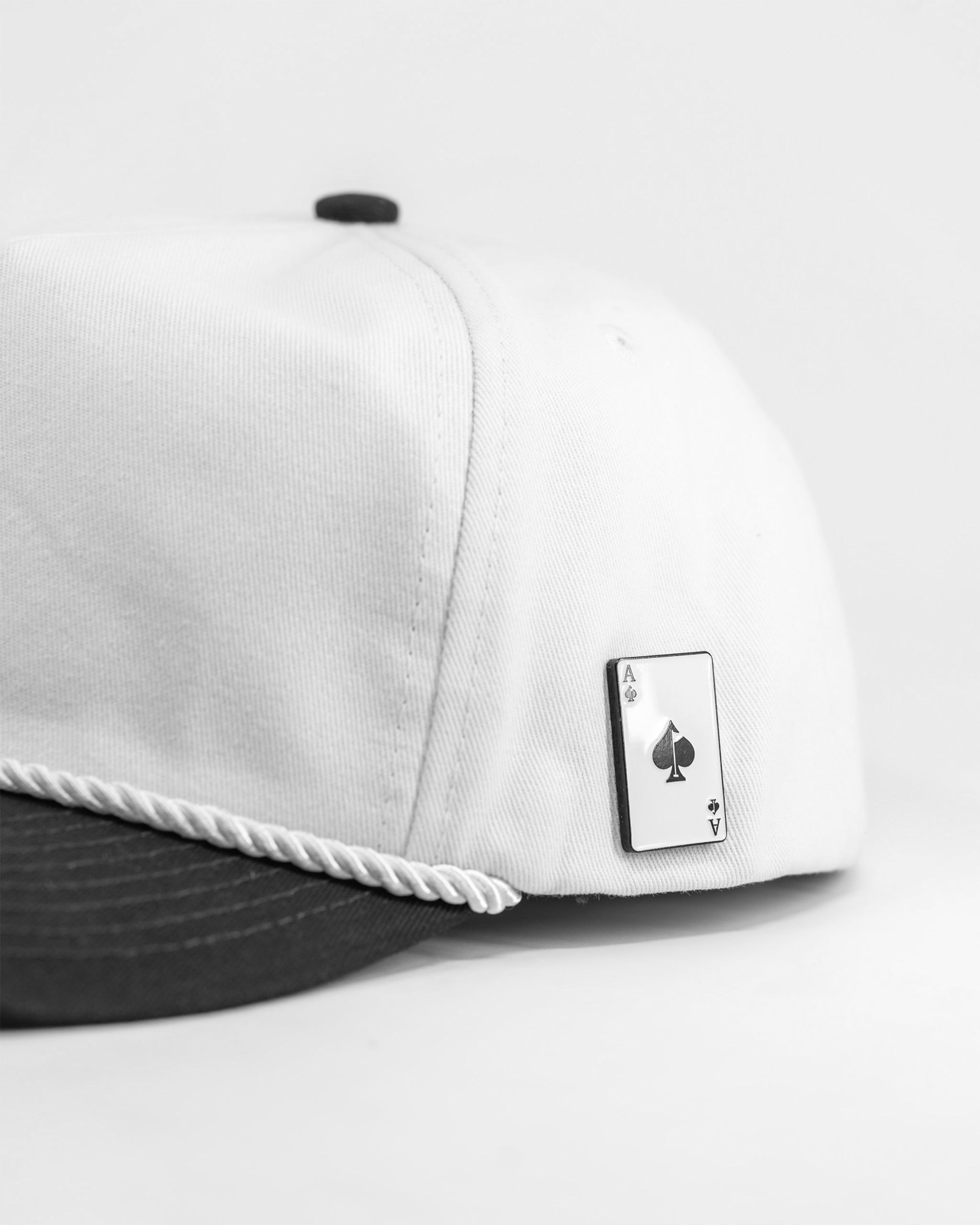 Heritage Rope Hat in black with white trim featuring an Alaska design and a detachable ball marker.