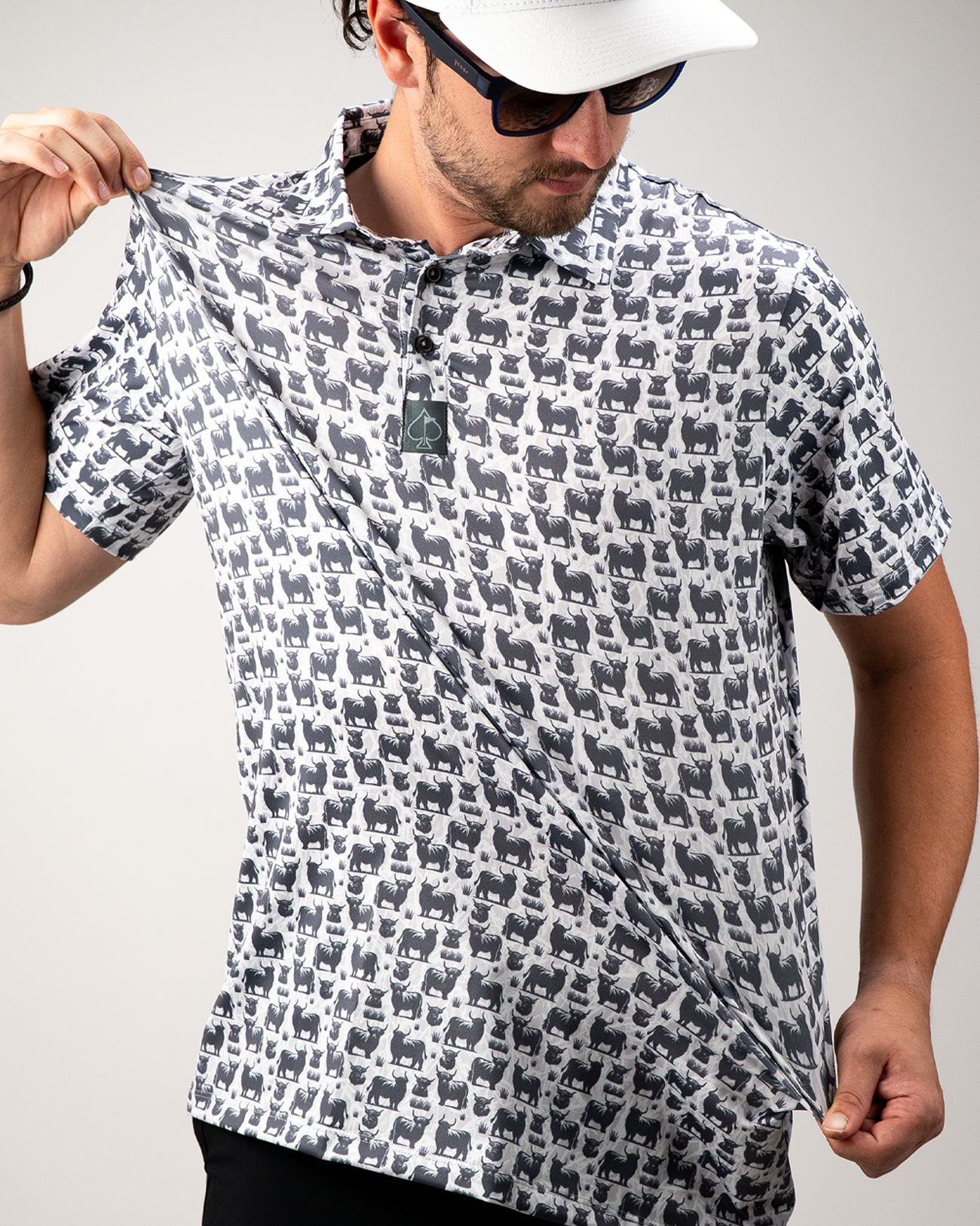 Man showcasing a Highland Cow patterned polo shirt, highlighting its unique design and relaxed fit.