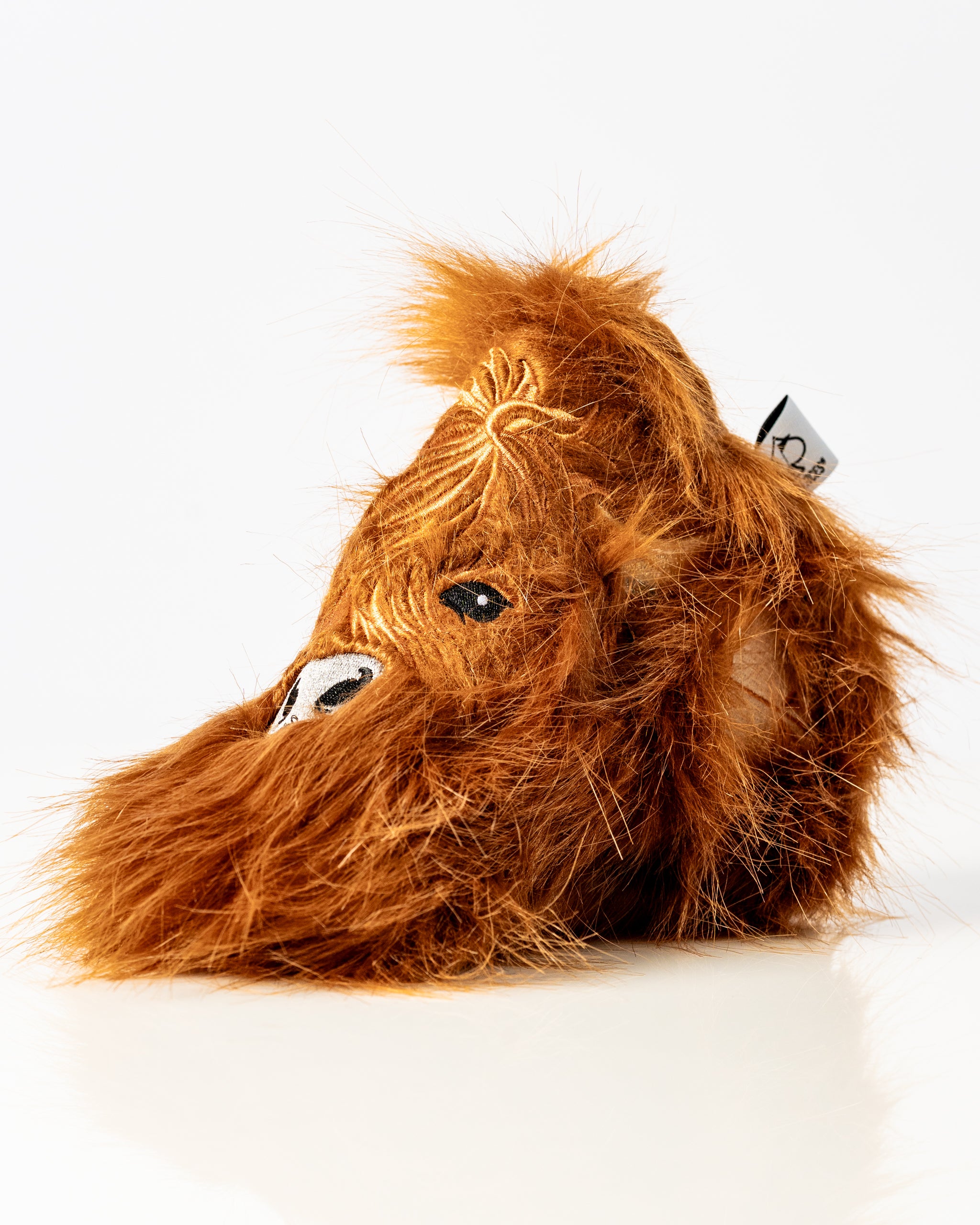 Highland cow blade putter cover featuring a fluffy orange-brown design, perfect for adding personality to your golf game.