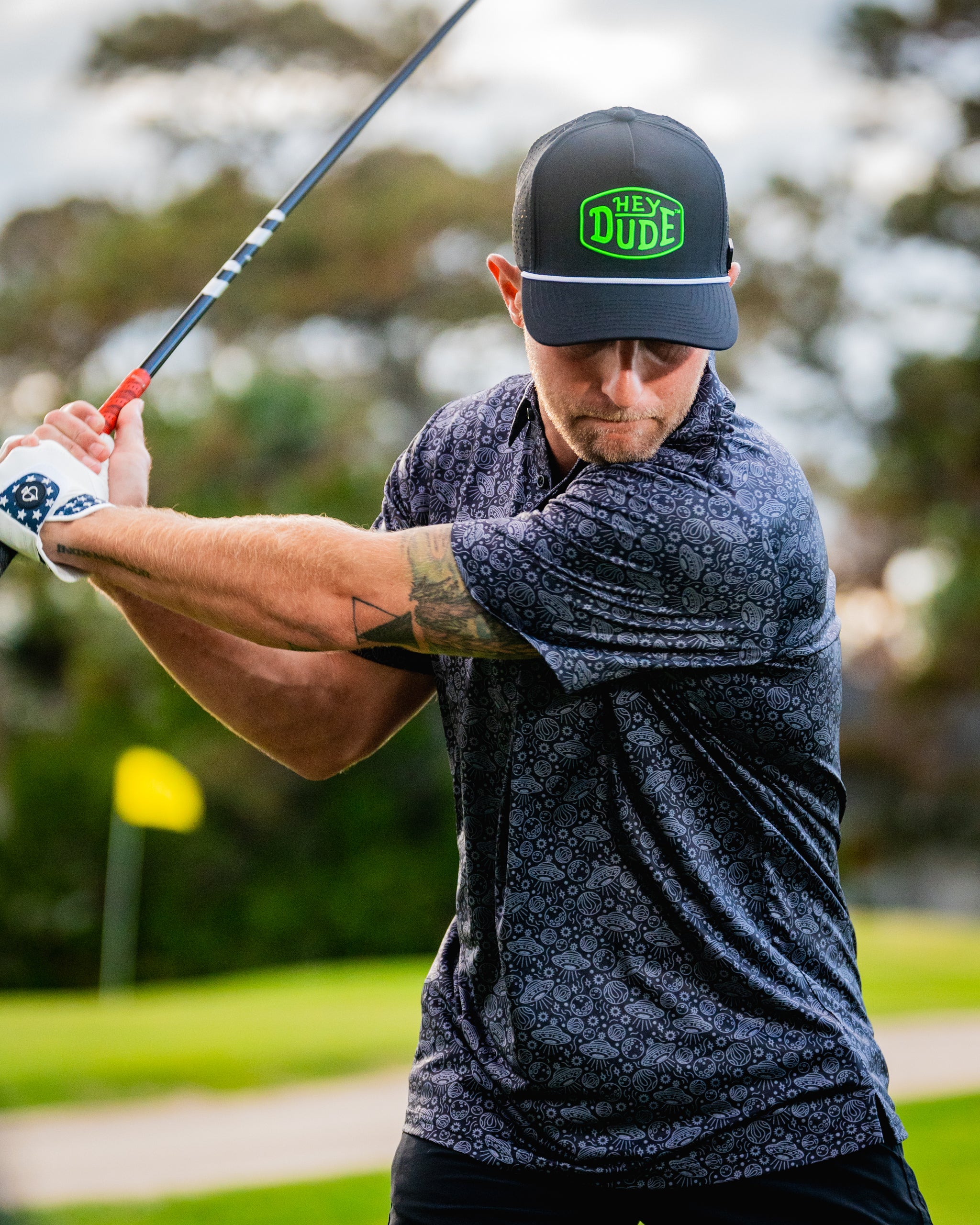 Black HEYDUDE Black Hole shoes displayed on a wooden surface, showcasing their stylish design and lightweight fabric.