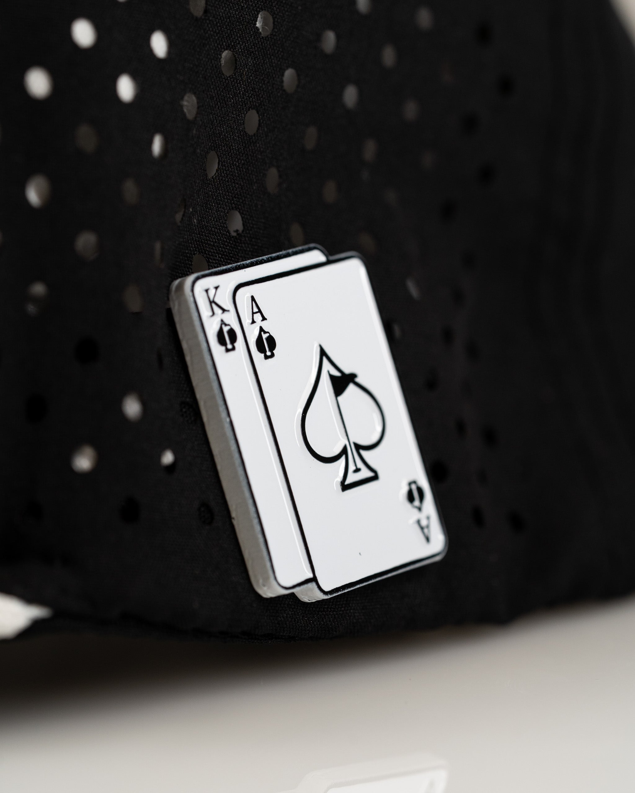 Black perforated rope hat featuring a stylish Ace and King card design for a bold golf look. Perfect for standout players.