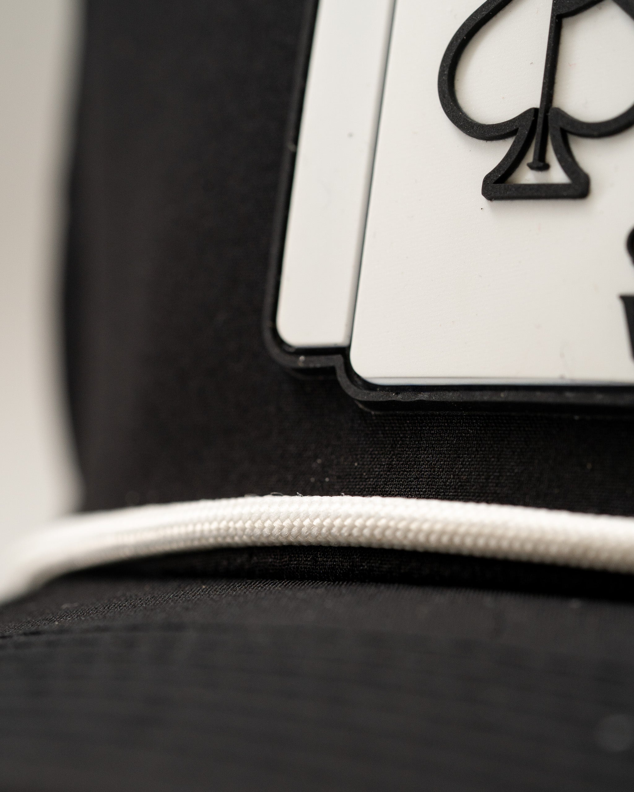 Black perforated rope hat featuring a bold Ace and King playing card design, perfect for stylish golfers.