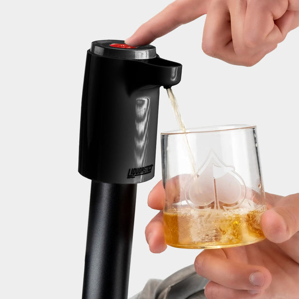 Black portable drink dispenser with a red button, pouring whiskey into a glass with a spade design, perfect for bold golf ...