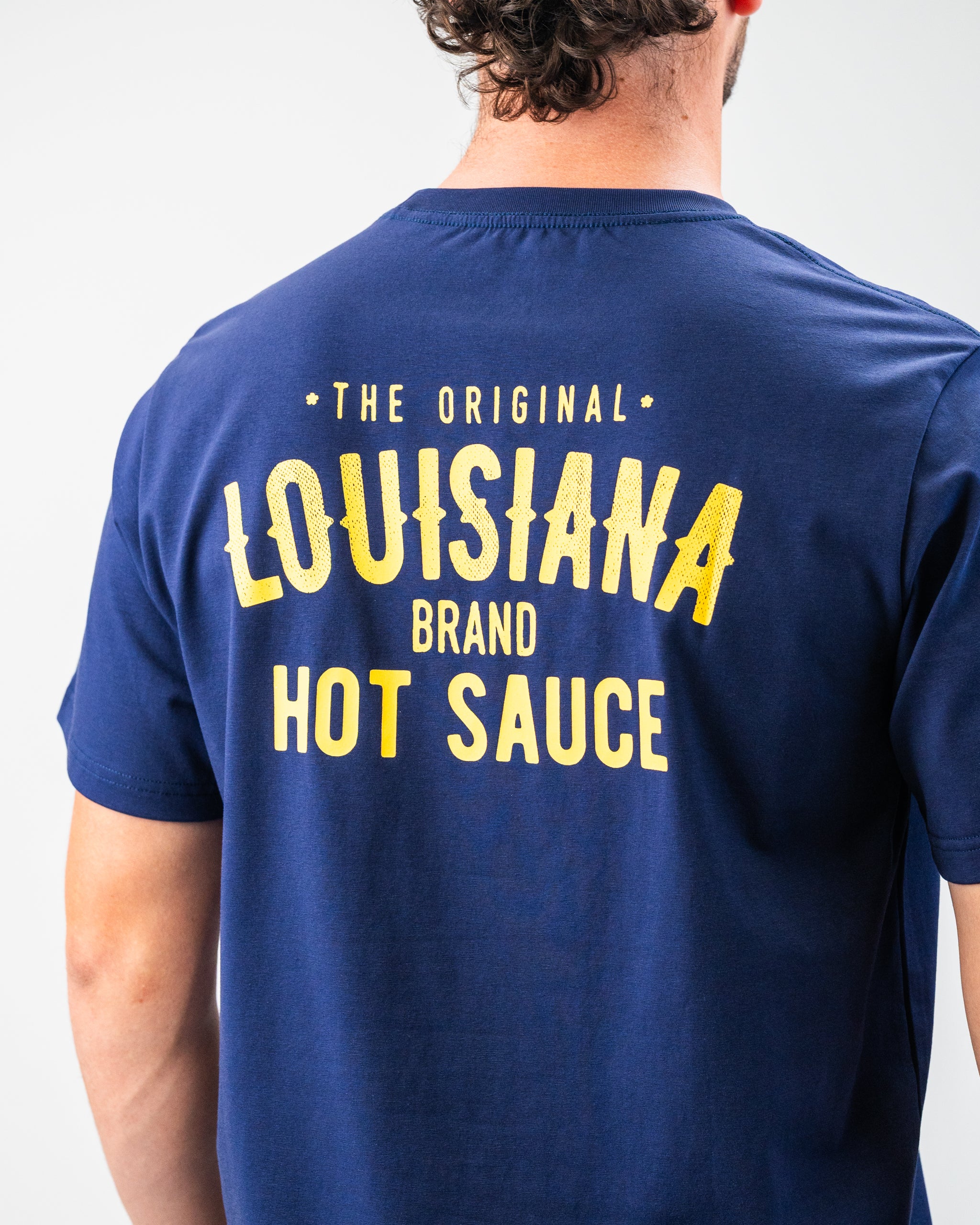 Blue T-shirt with bold yellow "Louisiana Hot Sauce" text, perfect for standout golf apparel and accessories.