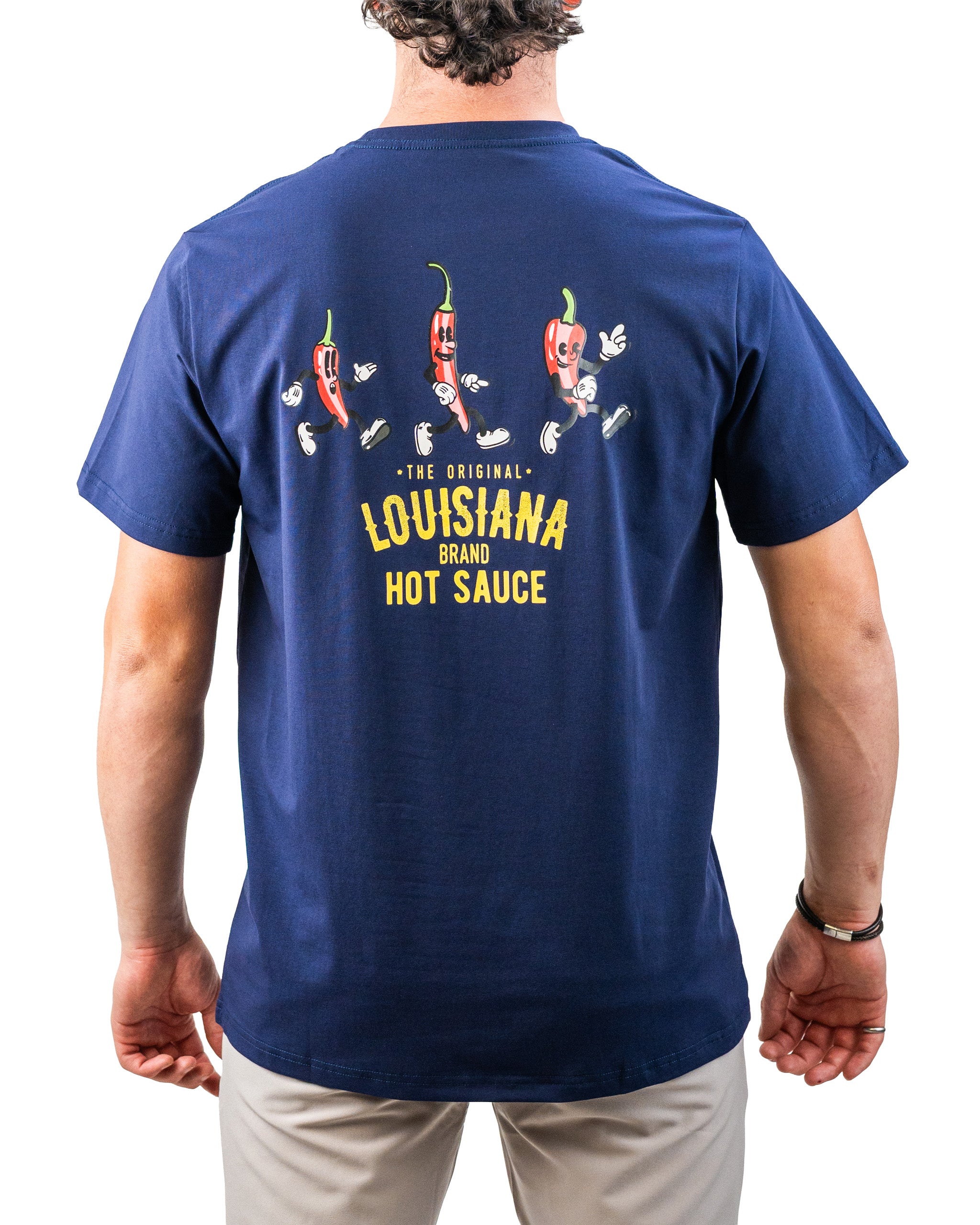 Back view of a navy blue golf t-shirt featuring cartoon hot sauce peppers with playful faces, arms, and legs, and bold yel...