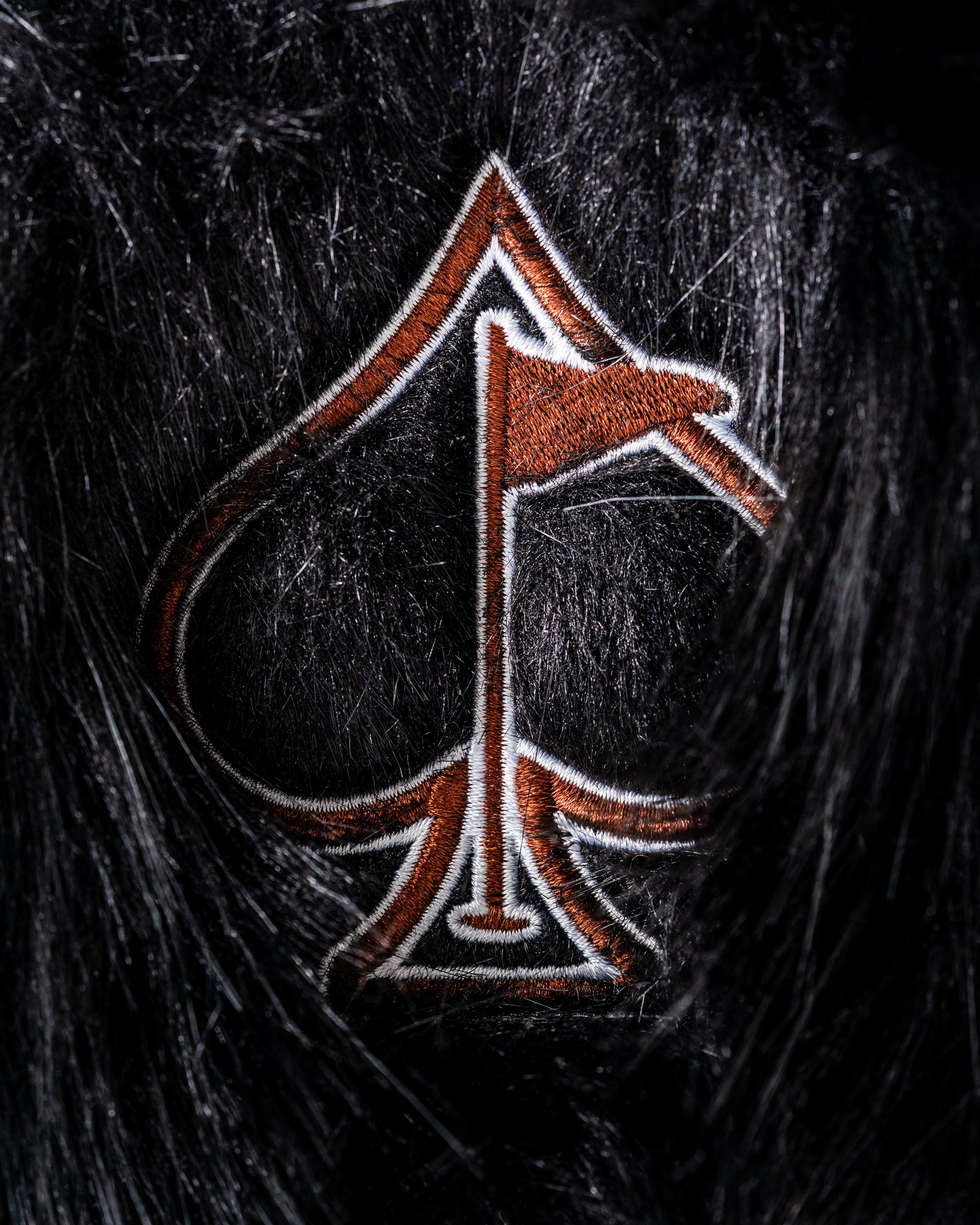 Woolly Mammoth driver cover featuring a detailed spade logo in orange and white on a black fur background.