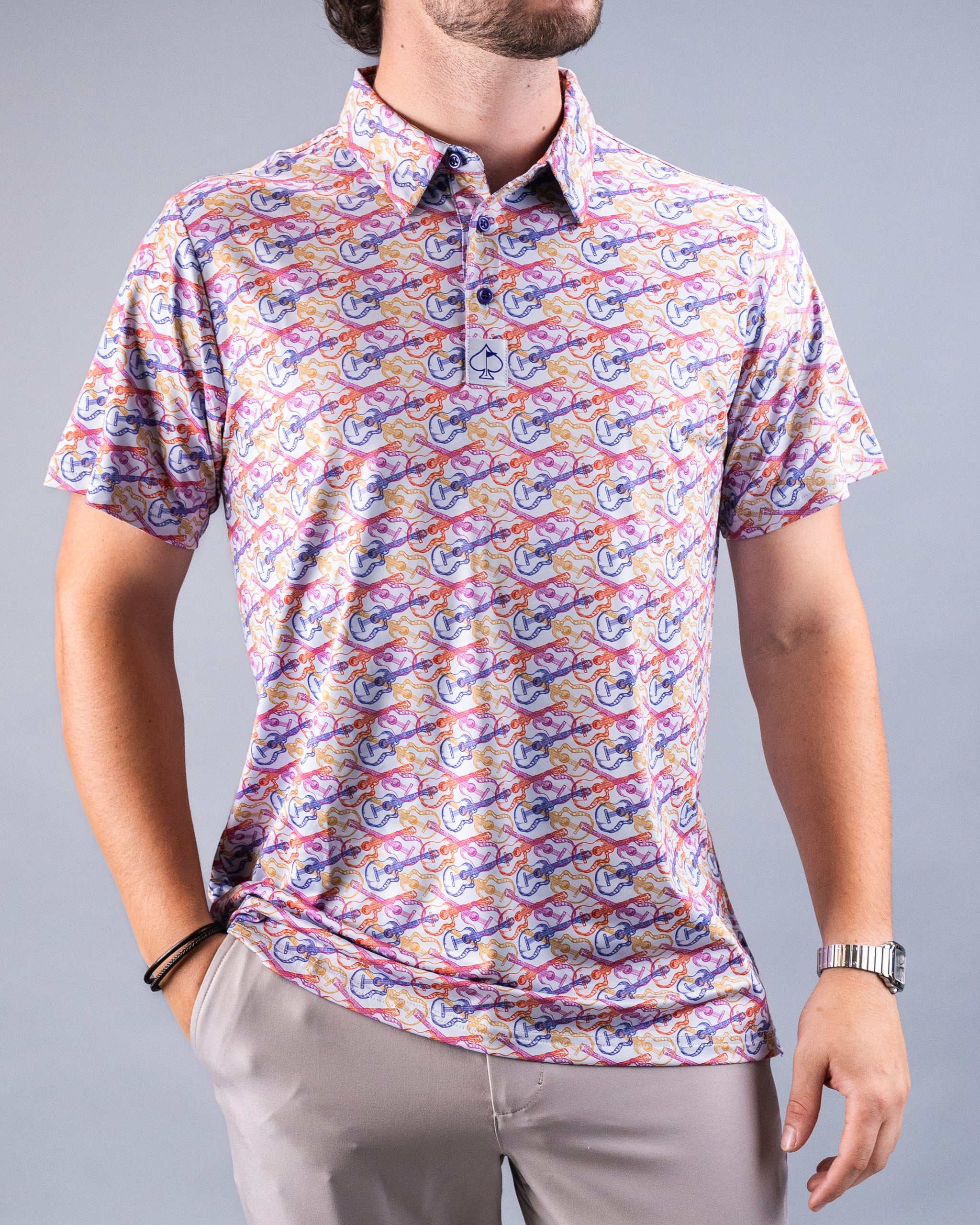 Men's polo shirt with colorful guitar pattern in purple, pink, orange, and yellow on a white background, featuring a small...