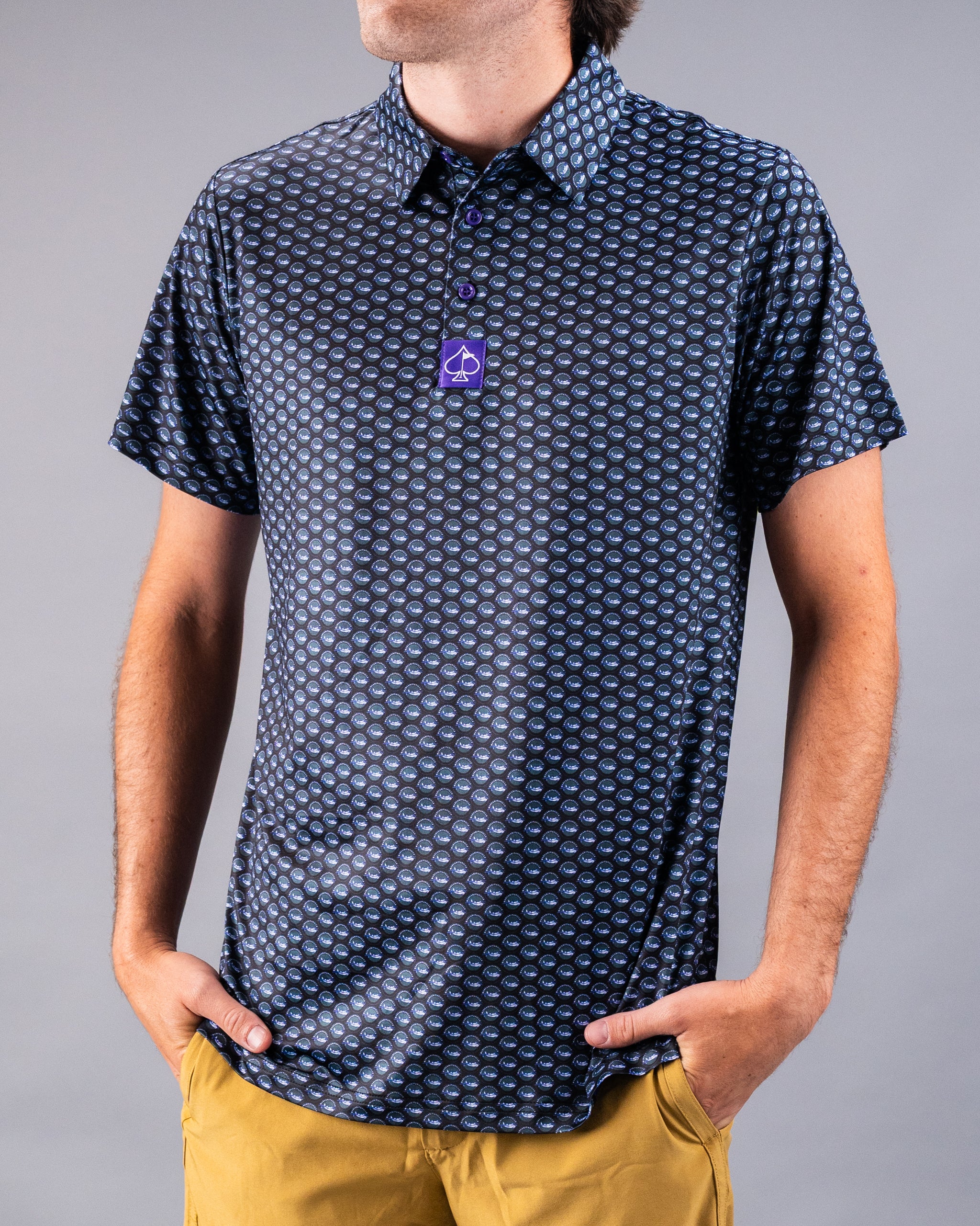 Men's navy golf shirt with a blue geometric pattern, short sleeves, and a purple spade logo tag.
