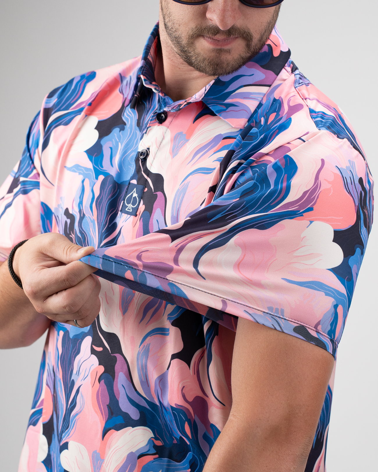 A golfer showcases the vibrant Melting Floral polo shirt, highlighting its colorful floral design and lightweight fabric.